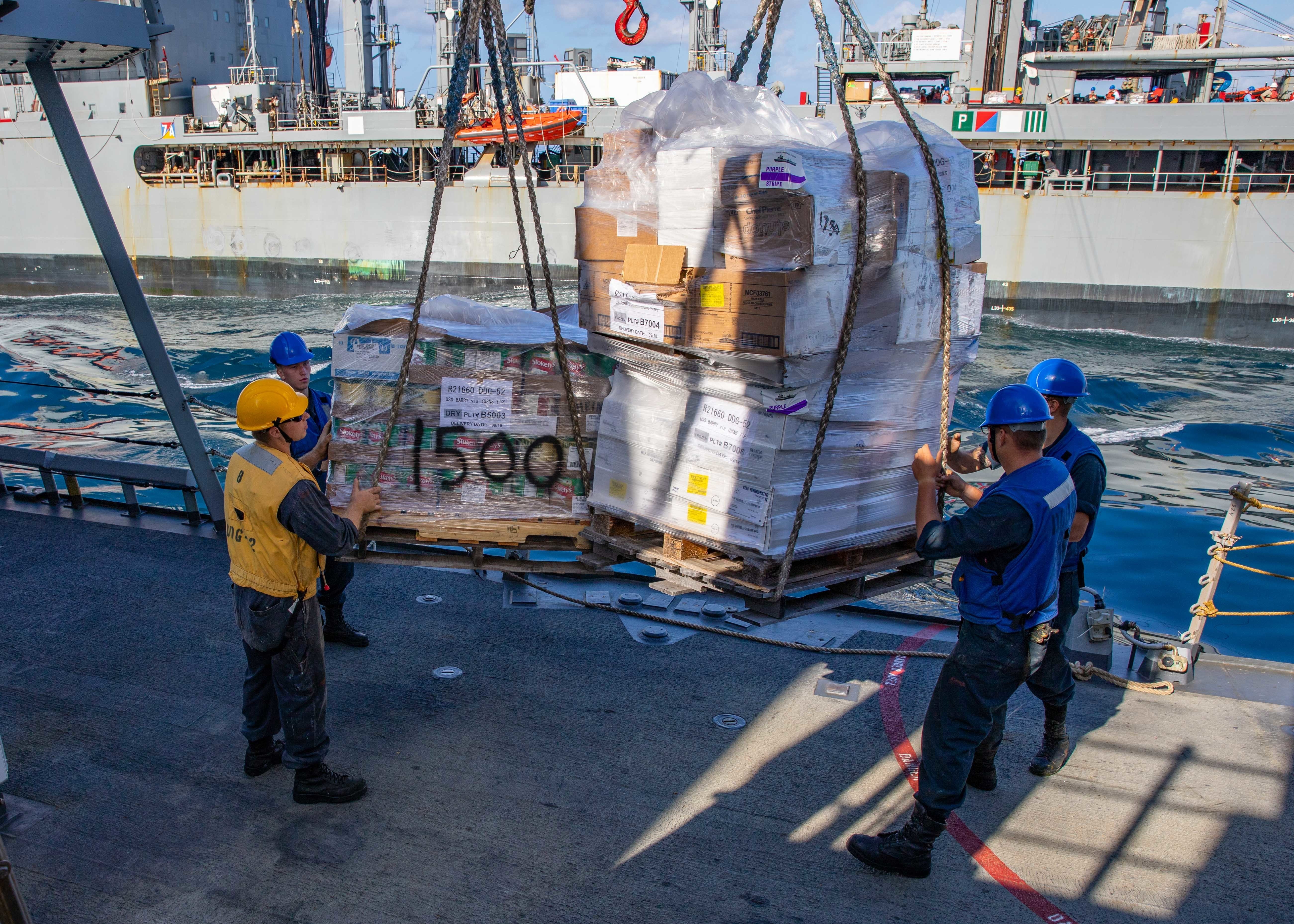 EAST CHINA SEA (Sept. 20, 2021) Sailors aboard Arleigh Burke-class guided-missile destroyer USS Barry (DDG 52) receive pallets of supplies from Henry J. Kaiser class fleet replenishment oiler USNS Tippecanoe (T-AO 199) during a replenishment-at-sea.