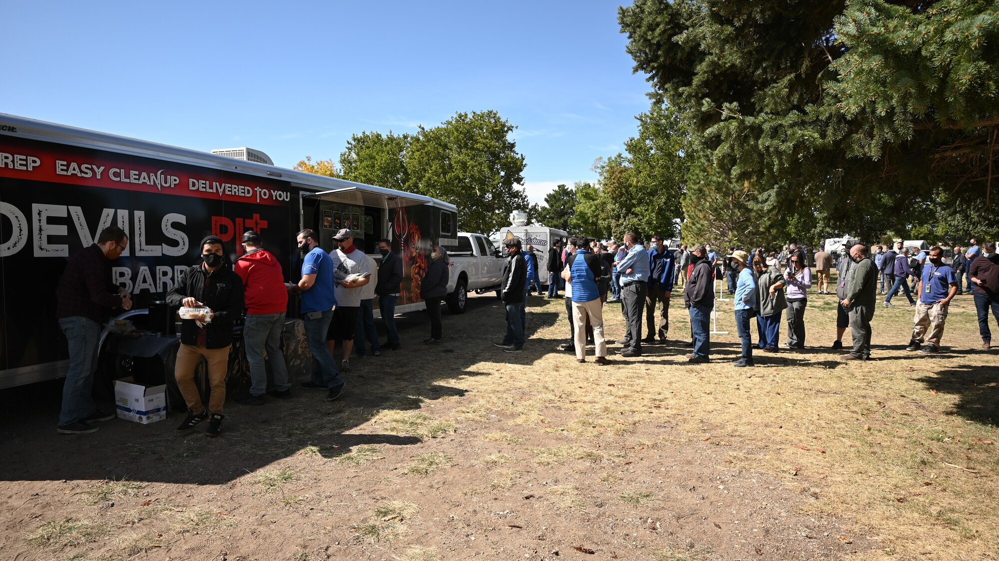 Attendees of the 2021 Civilian Appreciation Picnic get lunch from food trucks at Hill Air Force Base, Utah, Sept. 29, 2021. Organized by the 75th Force Support Squadron, the event was held to recognize the hard work of civilians across the base. (U.S. Air Force photo by R. Nial Bradshaw)