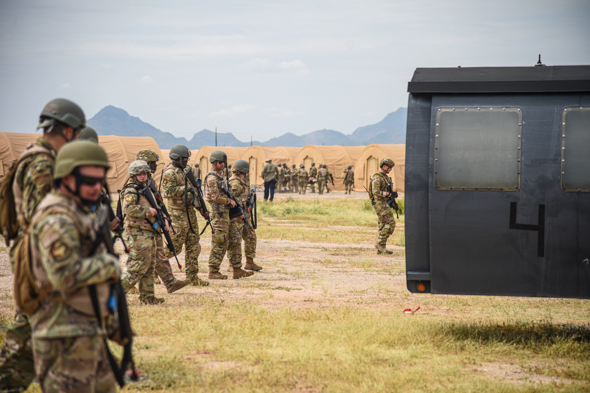 Pictured above is a large group of Airmen walking side-by-side in a line in a field.