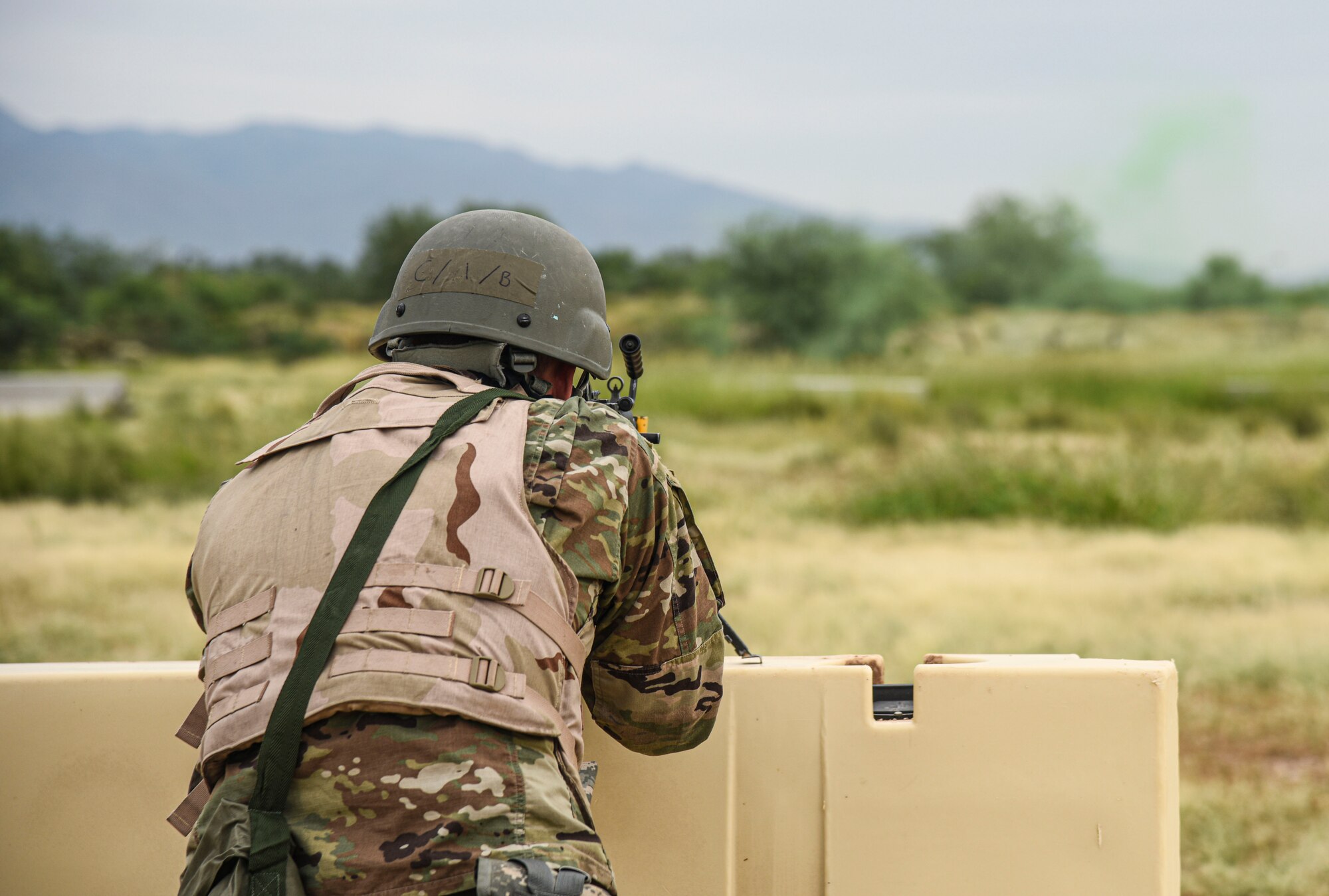 Pictured above is an Airmen standing behind a barricade aiming his gun over the barricade.