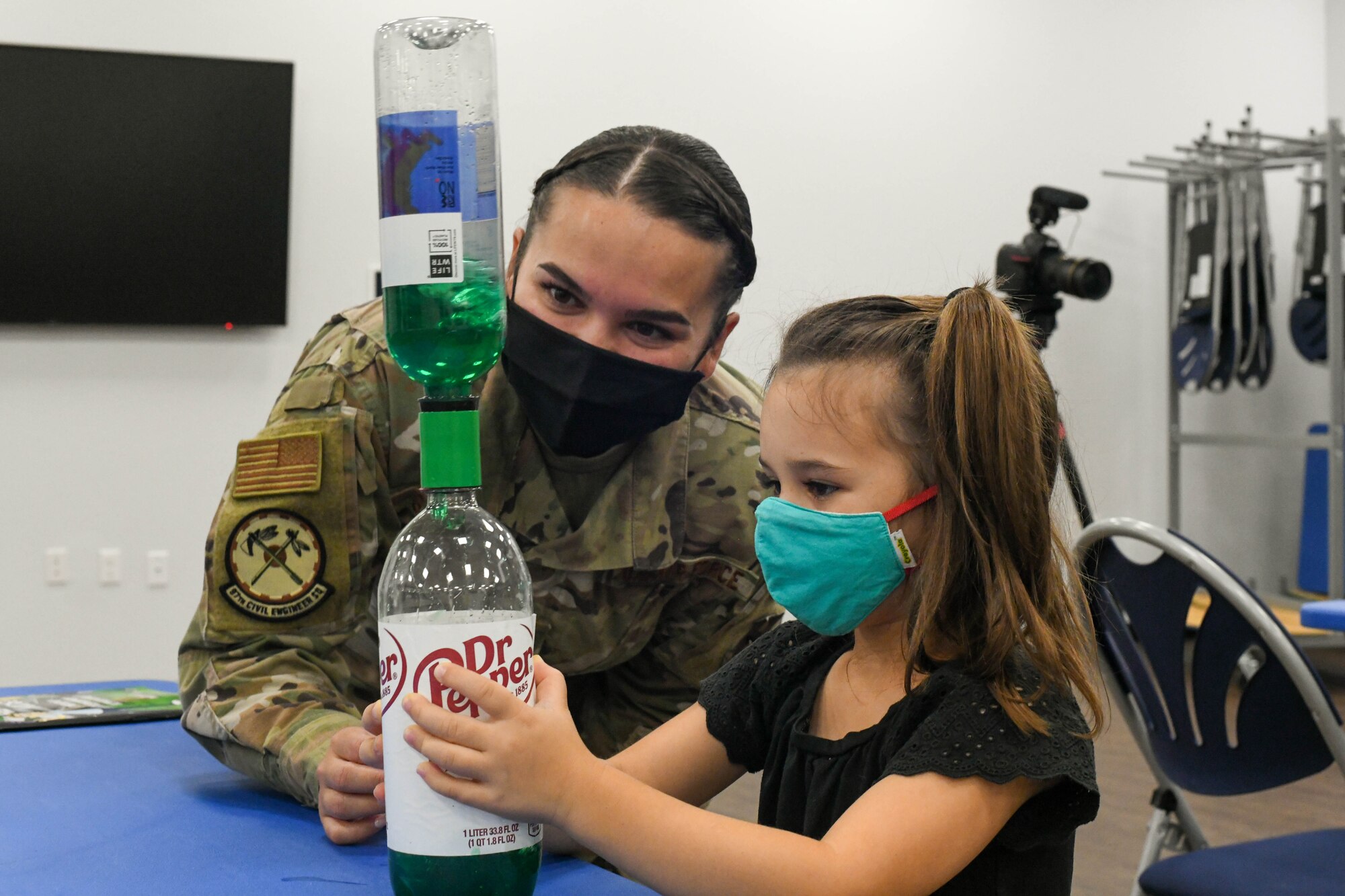 U.S. Air Force Staff Sgt. Katrina Jimenez, 97th Civil Engineer Squadron (CES) Emergency Management Flight noncommissioned officer in charge, and Viviana Gadoury, a home-school student, watch a water tornado in a bottle, on Altus Air Force Base, Oklahoma, Sept. 9, 2021. Activities during National Preparedness Month included setting up information booths at different events, visiting local and homeschool school students for educational fun and hosting a preparedness kit making event.  (U.S. Air Force Photo by Airman 1st Class Trenton Jancze)