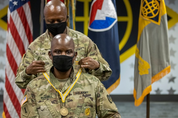 Command Sgt. Maj. Kenneth F. Law, U.S. Army Financial Management Command senior enlisted advisor, presents Sgt. Maj. Damien Russell, USAFMCOM Operations senior enlisted advisor, with the 837th Maj. Gen. Nathan Towson Medallion during a special ceremony at the Maj. Gen. Emmett J. Bean Federal Center in Indianapolis Aug. 26. The Towson Medallion was established by the Army Finance Corps Association on May 7, 1993, and is awarded in recognition of demonstrated exemplary contribution and service to the Army Finance Corps. (U.S. Army photo by Mark R. W. Orders-Woempner)