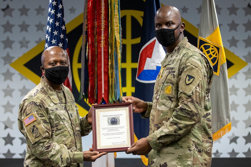 Command Sgt. Maj. Kenneth F. Law, U.S. Army Financial Management Command senior enlisted advisor, presents Sgt. Maj. Damien Russell, USAFMCOM Operations senior enlisted advisor, with the 837th Maj. Gen. Nathan Towson Medallion during a special ceremony at the Maj. Gen. Emmett J. Bean Federal Center in Indianapolis Aug. 26. The Towson Medallion was established by the Army Finance Corps Association on May 7, 1993, and is awarded in recognition of demonstrated exemplary contribution and service to the Army Finance Corps. (U.S. Army photo by Mark R. W. Orders-Woempner)