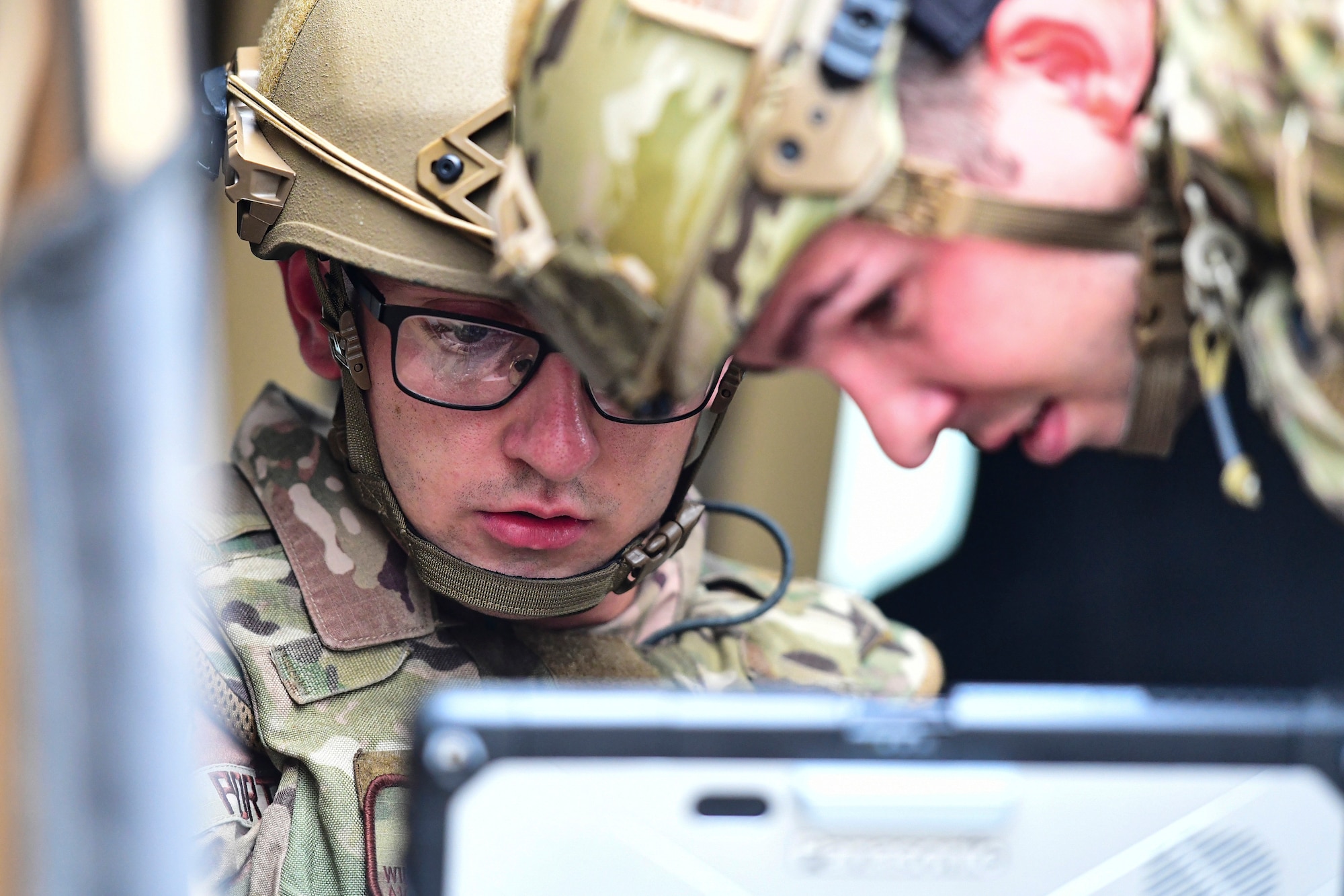 Airmen operate a robot.