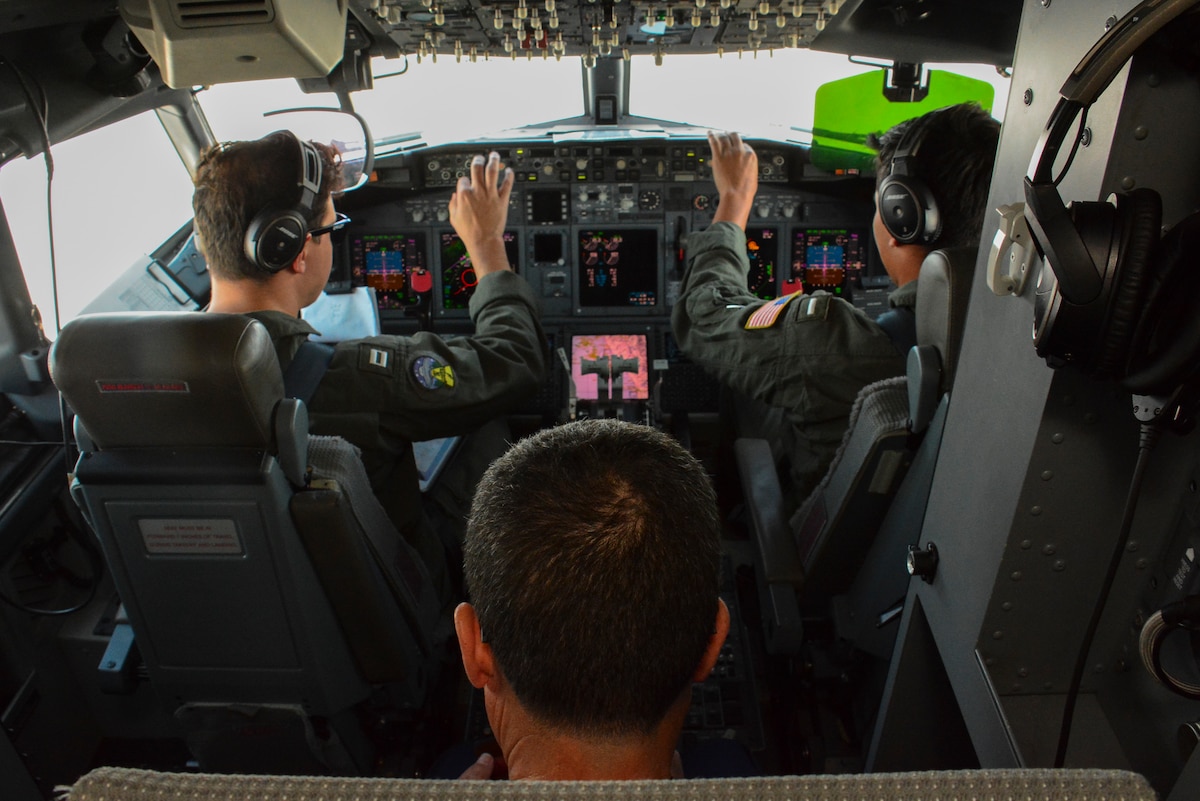 Peruvian Chief of Naval Operations Admiral Alberto Alcala observes as U.S. Navy Lt. Esteban Vasquez and U.S. Navy Lt. j.g. Sammy Benavdez prepare for landing aboard a P-8A Poseidon aircraft