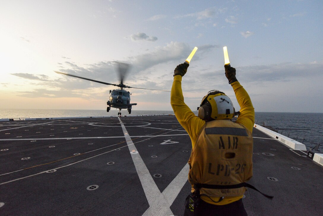 A Sailor directs a MH-60R Sea Hawk helicopter attached to the “Scorpions” of Helicopter Maritime Strike Squadron (HSM) 49 to take off from flight deck during UNITAS LXII, Sept. 27, 2021.