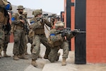 U.S. Marine Corps Lance Cpl. Christian Fletcher, a light armored vehicle crewman with Special Purpose Marine Air-Ground Task Force – UNITAS, and a Peruvian Marine demonstrate a strategy for advancing in a hostile environment during a military operations in urbanized terrain training evolution at the Base de Infanteria de Marina, Peru, Sept. 26, 2021, during exercise UNITAS LXII.