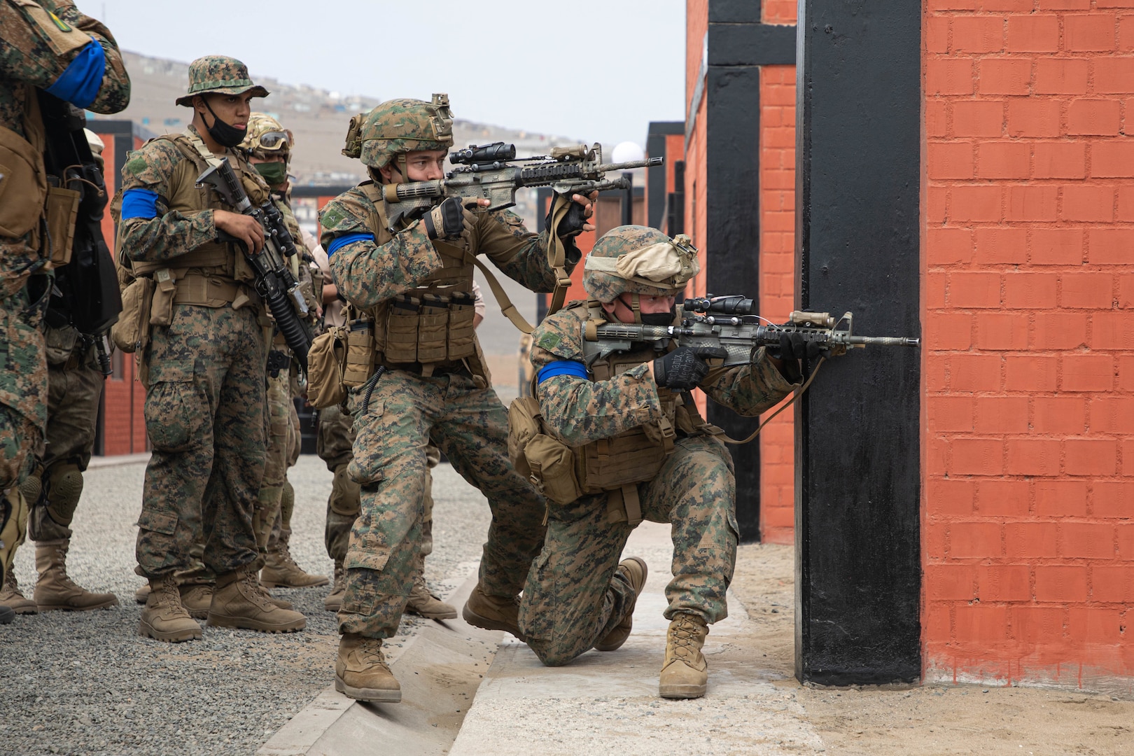 U.S. Marine Corps Lance Cpl. Christian Fletcher, a light armored vehicle crewman with Special Purpose Marine Air-Ground Task Force – UNITAS, and a Peruvian Marine demonstrate a strategy for advancing in a hostile environment during a military operations in urbanized terrain training evolution at the Base de Infanteria de Marina, Peru, Sept. 26, 2021, during exercise UNITAS LXII.