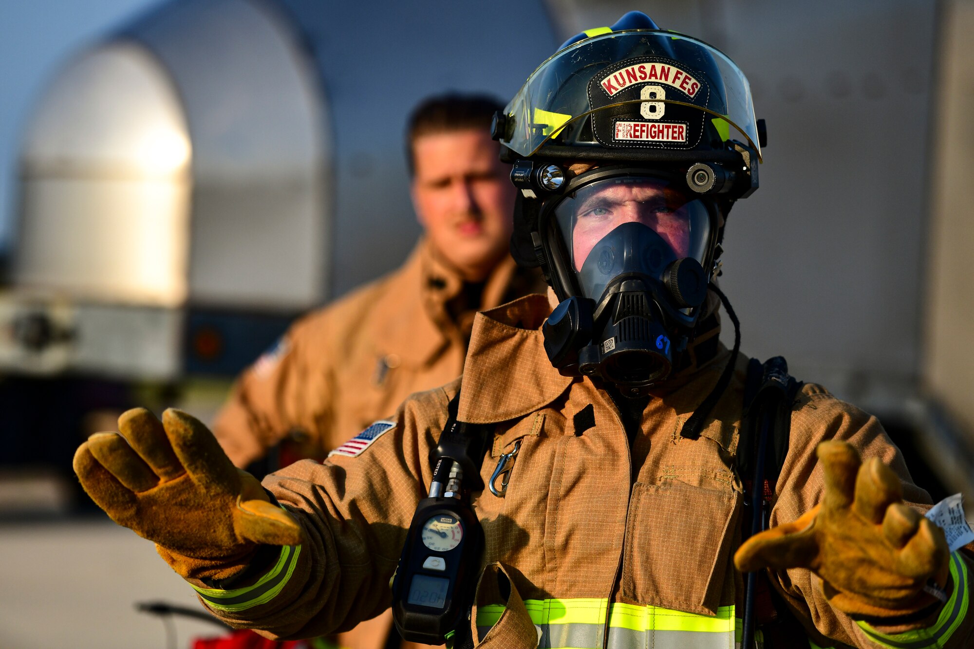 A firefighter teaches Airmen about fire safety.
