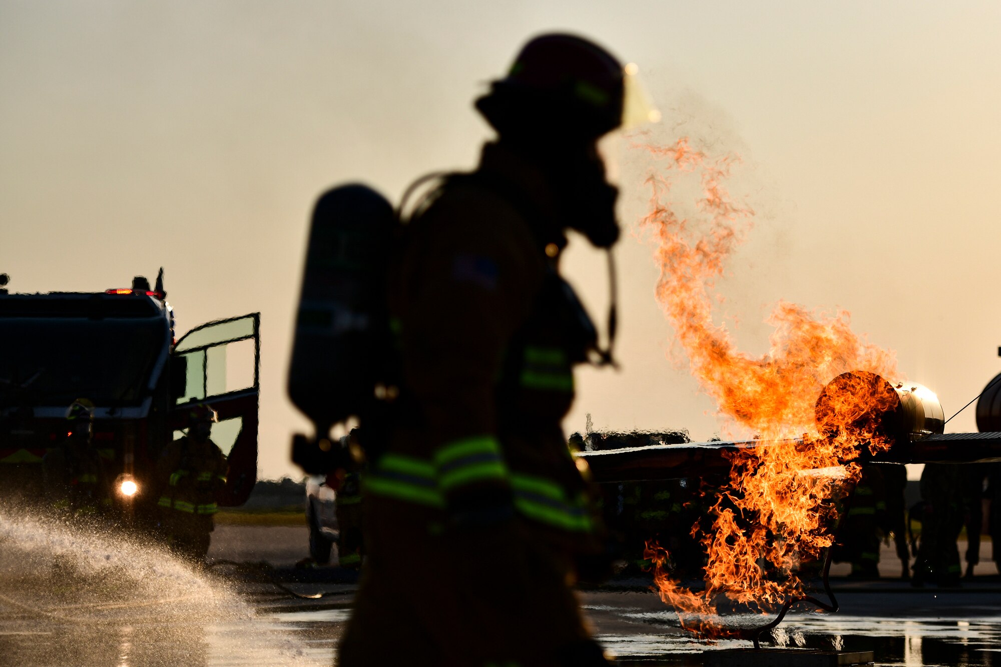 An Airman walks past a fire.