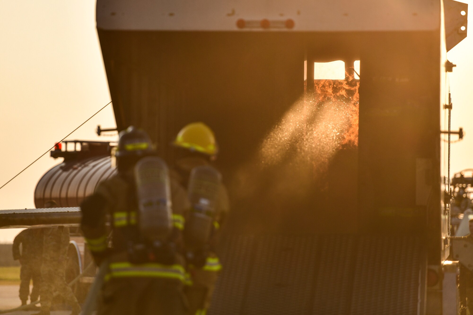 Airmen approach a fire.