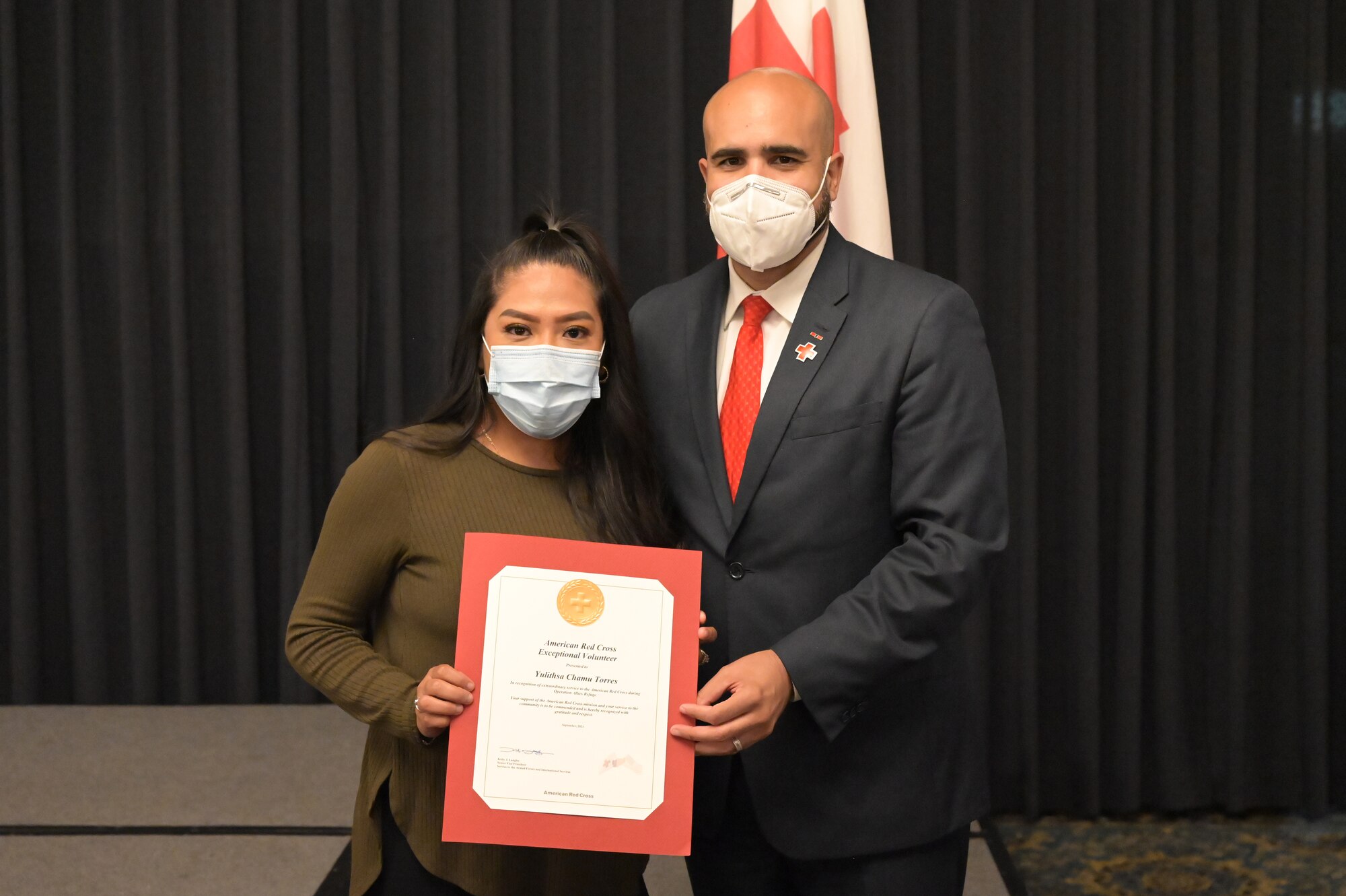 Two people holding a certificate and posing for a photo.