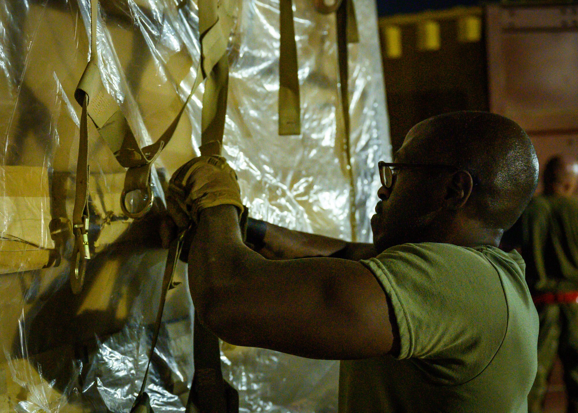 A U.S. Air Force Airman secures the bindings on a pallet of cots to be sent to Al Udeid Air Base, Qatar, at Prince Sultan Air Base, Kingdom of Saudi Arabia, Aug. 20, 2021. The 378th Air Expeditionary Wing provided air support, logistics, manpower and resources to U.S. Air Forces Central in support of the evacuation of American citizens, special immigrant visa applicants and other at-risk individuals from Afghanistan. (U.S. Air Force photo by Senior Airman Samuel Earick)