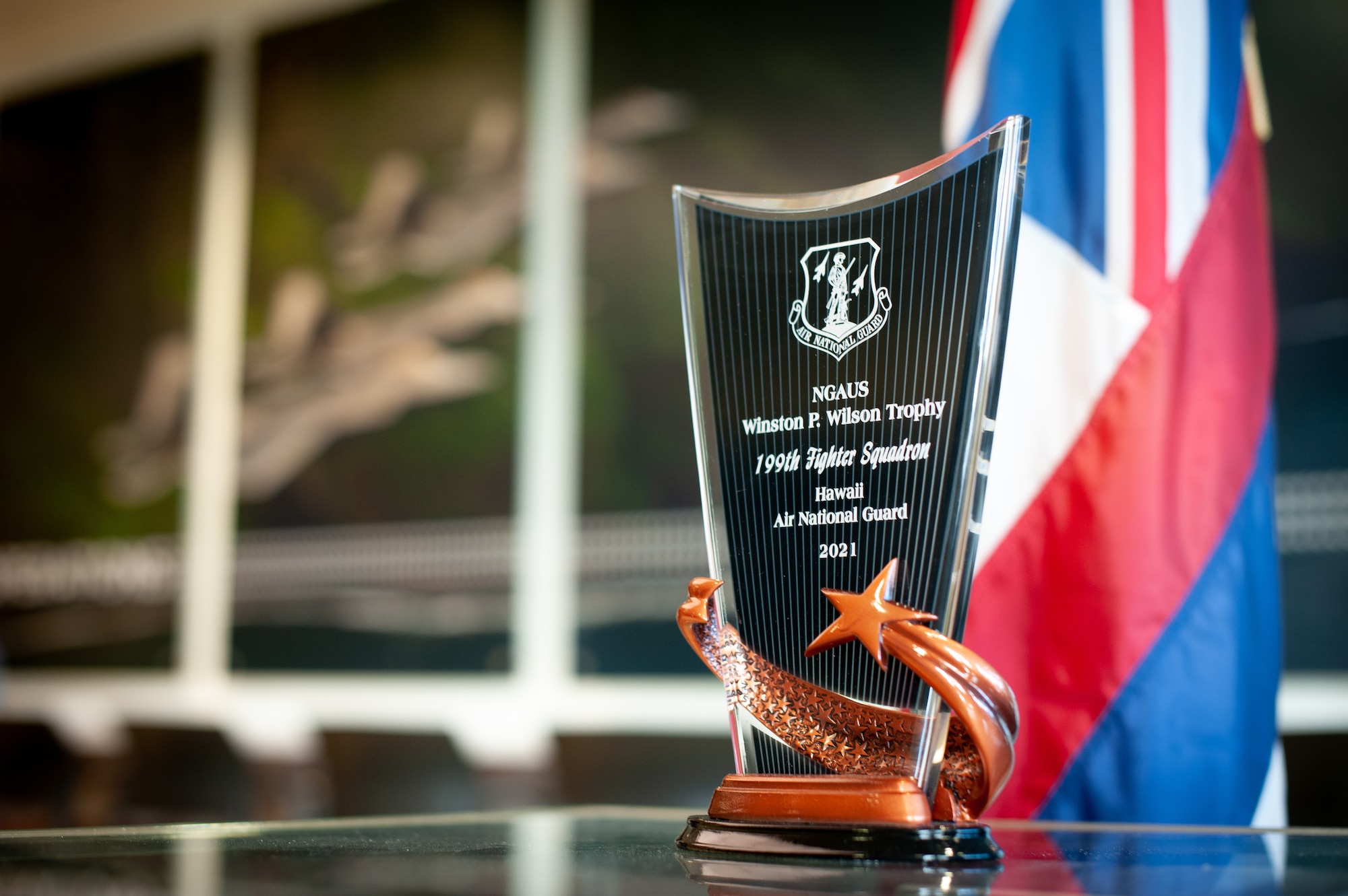 The Winston P. Wilson Trophy for 2021 is displayed at the Hawaii Air National Guard’s 199th Fighter Squadron on Sept. 28, 2021, at Joint Base Pearl Harbor-Hickam, Hawaii. The 199th FS was recognized on behalf of the National Guard Association of the U.S., setting the unit apart from more than 30 other flying squadrons equipped with fighter and reconnaissance aircraft.  The trophy is bestowed annually to recognize top-performing units, based on overall effectiveness during exercises, deployments, inspection results, accident prevention and many other significant contributions. (U.S. Air National Guard photo by Staff Sgt. John Linzmeier)