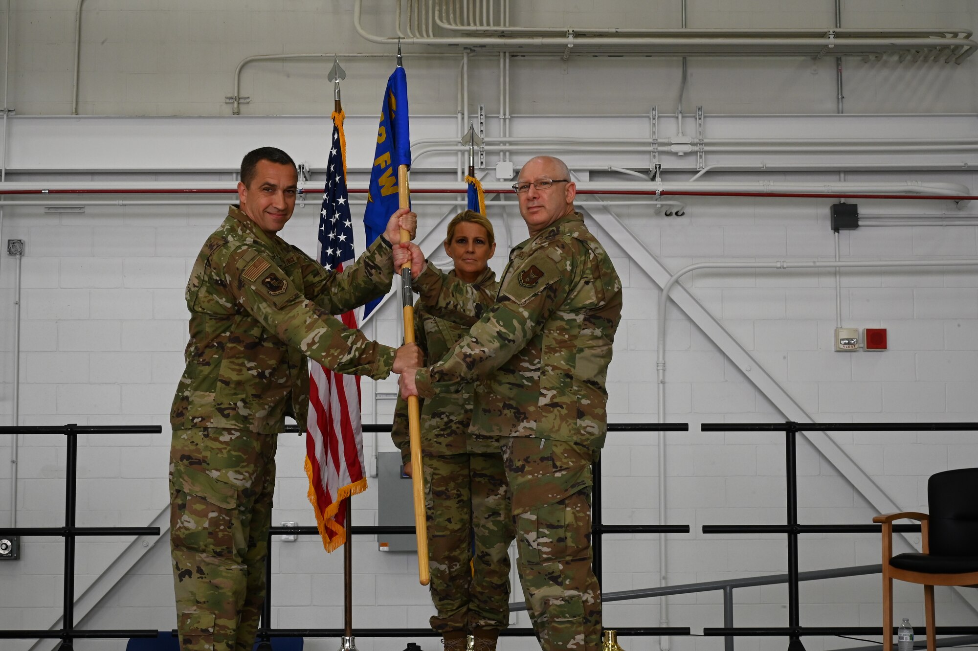 A man passes a blue flag to an older man.
