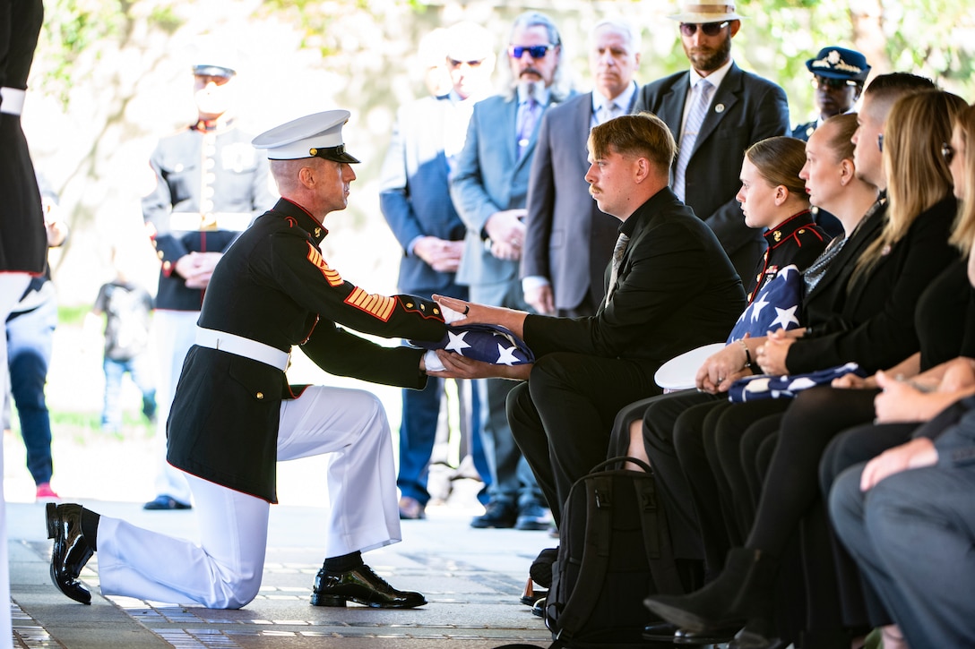 Jarod Gee is presented the U.S. flag following military funeral honors with funeral escort for his spouse, U.S. Marine Corps Sgt. Nicole L. Gee, in Section 60 of Arlington National Cemetery, Arlington, Virginia, Sept. 29, 2021.
