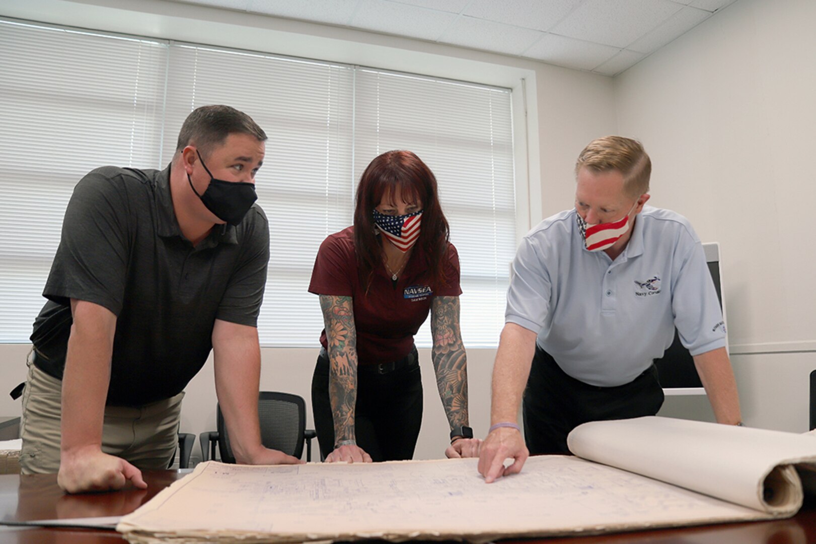 IMAGE: Naval Surface Warfare Center Dahlgren Division Dam Neck Activity (NSWCDD DNA) Director of Facilities Rob Peed (right), reviews historical building plans with Safety and Environmental Manager G.G. Murphy (center) and Facilities Manager David Crane (left) in Virginia Beach, Va. Peed and the NSWCDD DNA Facilities Team completed several renovations and improvements throughout the COVID-19 pandemic, taking advantage of the low occupancy in the buildings as most employees worked from home