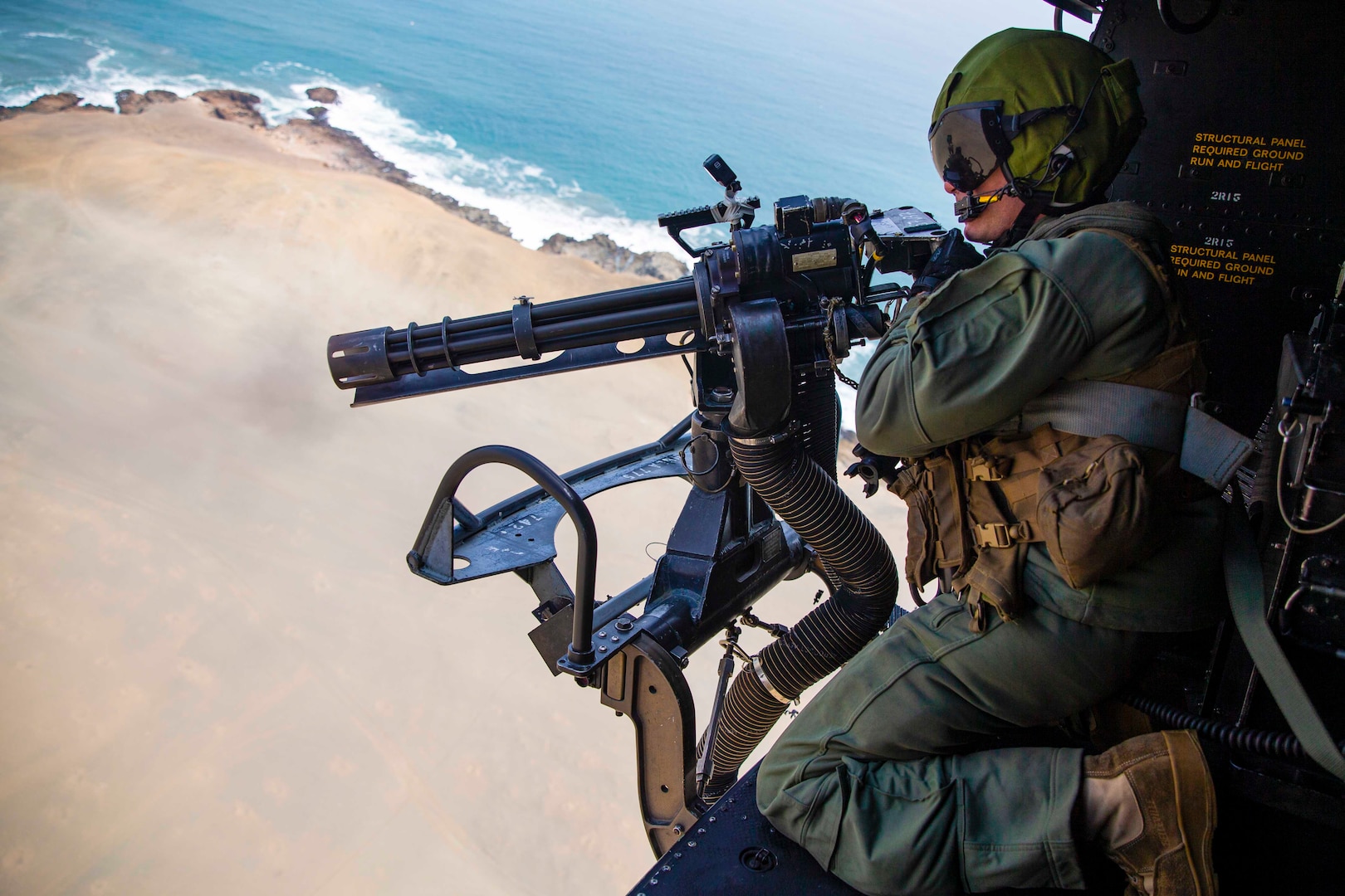 U.S. Marine Corps Sgt. Christophe J. Stump, an aerial observer with Special Purpose Marine Air-Ground Task Force - UNITAS, fires a GAU-17 minigun during UNITAS LXII in Lima, Peru, Sept. 28, 2021.