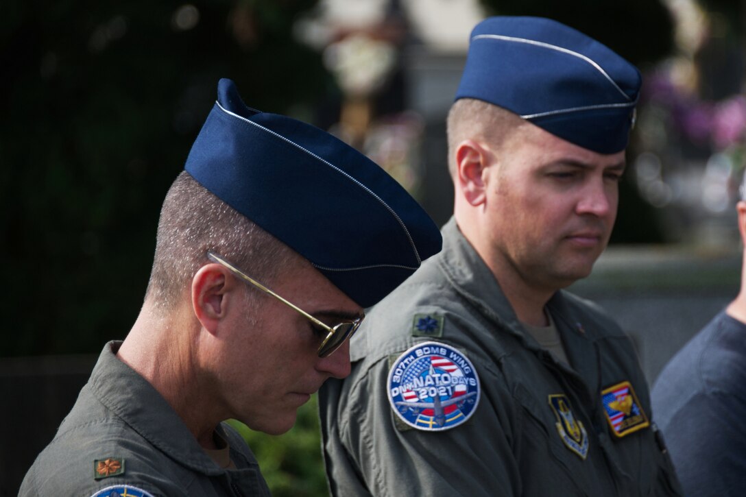 Two Airmen bow their heads.