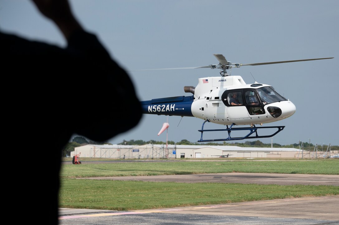 shadow of a man standing with a helicopter flying in the background.