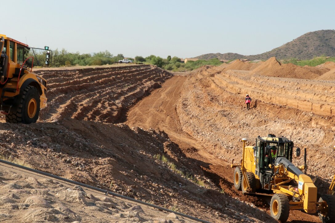 The U.S. Army Corps of Engineers Los Angeles District is working with the Flood Control District of Maricopa County, Arizona, to repair five levee systems using the Public Law 84-99 Rehabilitation and Inspection Program.

Work is currently underway in the New River Dam outlet channel in Peoria.

Here, a grader works the channel subgrade Sept. 28 as a dump truck waits to deliver more fill material.