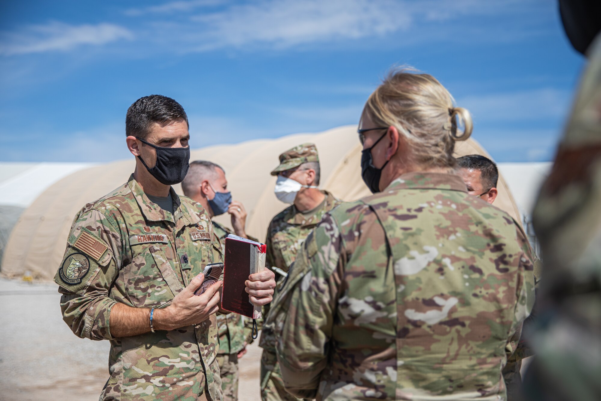 U.S. Air Force Lt. Col. Michael Hawkins, Task Force Holloman contracting lead, briefs U.S. Army North at Aman Omid Village during a visit to Holloman Air Force Base, New Mexico, Sept 23, 2021. The Department of Defense, through U.S. Northern Command, and in support of the Department of State and Department of Homeland Security, is providing transportation, temporary housing, medical screening, and general support for at least 50,000 Afghan evacuees at suitable facilities, in permanent or temporary structures, as quickly as possible. This initiative provides Afghan evacuees essential support at secure locations outside Afghanistan. (U.S. Army photo by Pfc. Anthony Sanchez)