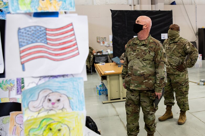 U.S. Army Col. Stan Whitten, U.S. Army North chaplain and U.S. Air Force Lt. Col. Dwayne Jones, Task Force-Holloman chaplain, look at pictures drawn by Afghan evacuees during their tour of the Operation Allies Welcome facilities on Holloman Air Force Base, New Mexico, Sept. 22, 2021. The Department of Defense, through the U.S. Northern Command, and in support of the Department of State and Department of Homeland Security, is providing transportation, temporary housing, medical screening, and general support for at least 50,000 Afghan evacuees at suitable facilities, in permanent or temporary structures, as quickly as possible. This initiative provides Afghan evacuees essential support at secure locations outside Afghanistan. 
(U.S. Army photo by Spc. Nicholas Goodman)