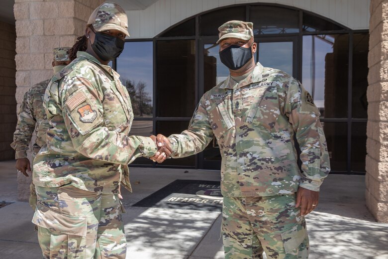 U.S. Army Sgt. Maj Wesley Burton, right, gives a coin to U.S. Air Force Tech. Sgt. Torry Reed, Task Force Holloman religious support noncommissioned officer in charge, after a tour of Task Force Holloman in support of Operation Allies Welcome on Holloman Air Force Base, New Mexico, Sept. 22, 2021. The Department of Defense, through the U.S. Northern Command, and in support of the Department of State and Department of Homeland Security, is providing transportation, temporary housing, medical screening, and general support for at least 50,000 Afghan evacuees at suitable facilities, in permanent or temporary structures, as quickly as possible. This initiative provides Afghan evacuees essential support at secure locations outside Afghanistan. 
(U.S. Army photo by Spc. Nicholas Goodman)