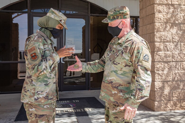 U.S. Air Force 1st Lt. Saleha Jabeen, Task Force Holloman cultural advisor, receives a coin from U.S. Army Col. Stan Whitten, U.S. Army North chaplain at the conclusion of a tour through TF Holloman in support of Operation Allies Welcome on Holloman Air Force Base, New Mexico, Sept. 22, 2021. The Department of Defense, through the U.S. Northern Command, and in support of the Department of State and Department of Homeland Security, is providing transportation, temporary housing, medical screening, and general support for at least 50,000 Afghan evacuees at suitable facilities, in permanent or temporary structures, as quickly as possible. This initiative provides Afghan evacuees essential support at secure locations outside Afghanistan. 
(U.S. Army photo by Spc. Nicholas Goodman)