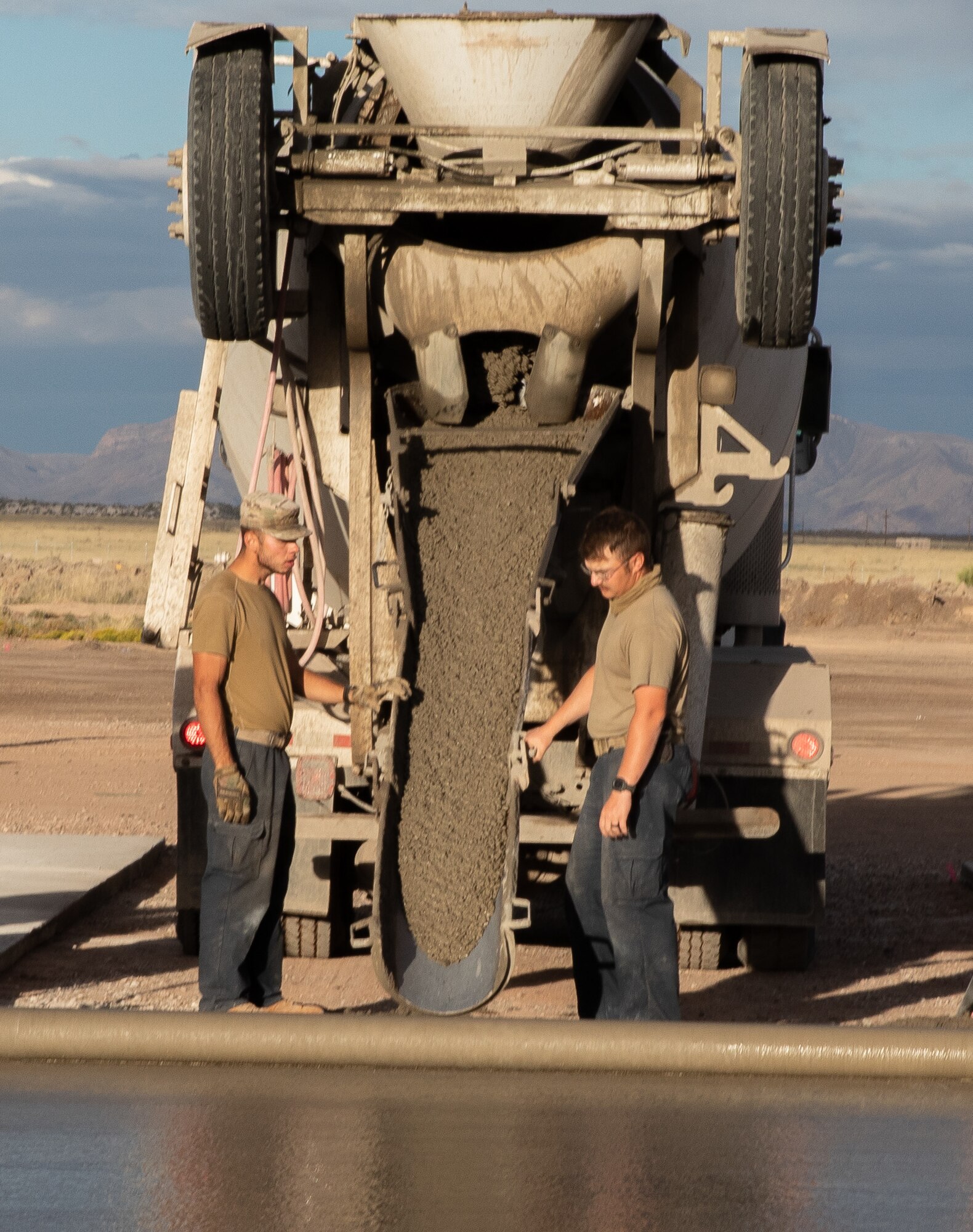 Airmen assigned to Task Force-Holloman pour concrete for a recreational area for Afghan evacuees on Holloman Air Force Base, New Mexico, Sept. 24, 2021. The Department of Defense, through the U.S. Northern Command, and in support of the Department of State and Department of Homeland Security, is providing transportation, temporary housing, medical screening, and general support for at least 50,000 Afghan evacuees at suitable facilities, in permanent or temporary structures, as quickly as possible. This initiative provides Afghan evacuees essential support at secure locations outside Afghanistan. (U.S. Army photo by Spc. Nicholas Goodman)