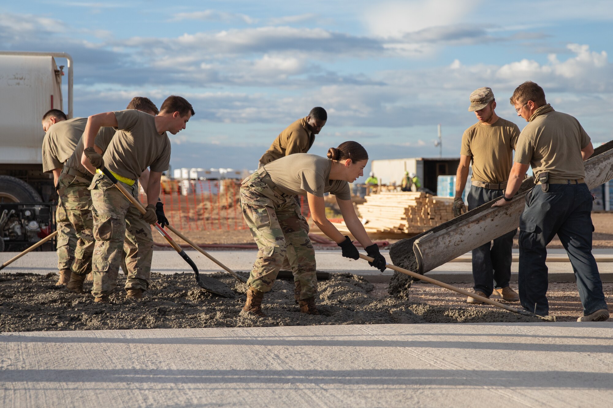 Airmen assigned to Task Force-Holloman spread fresh concrete for a recreational area for Afghan evacuees on Holloman Air Force Base, New Mexico, Sept. 24, 2021. The Department of Defense, through the U.S. Northern Command, and in support of the Department of State and Department of Homeland Security, is providing transportation, temporary housing, medical screening, and general support for at least 50,000 Afghan evacuees at suitable facilities, in permanent or temporary structures, as quickly as possible. This initiative provides Afghan evacuees essential support at secure locations outside Afghanistan. (U.S. Army photo by Spc. Nicholas Goodman)