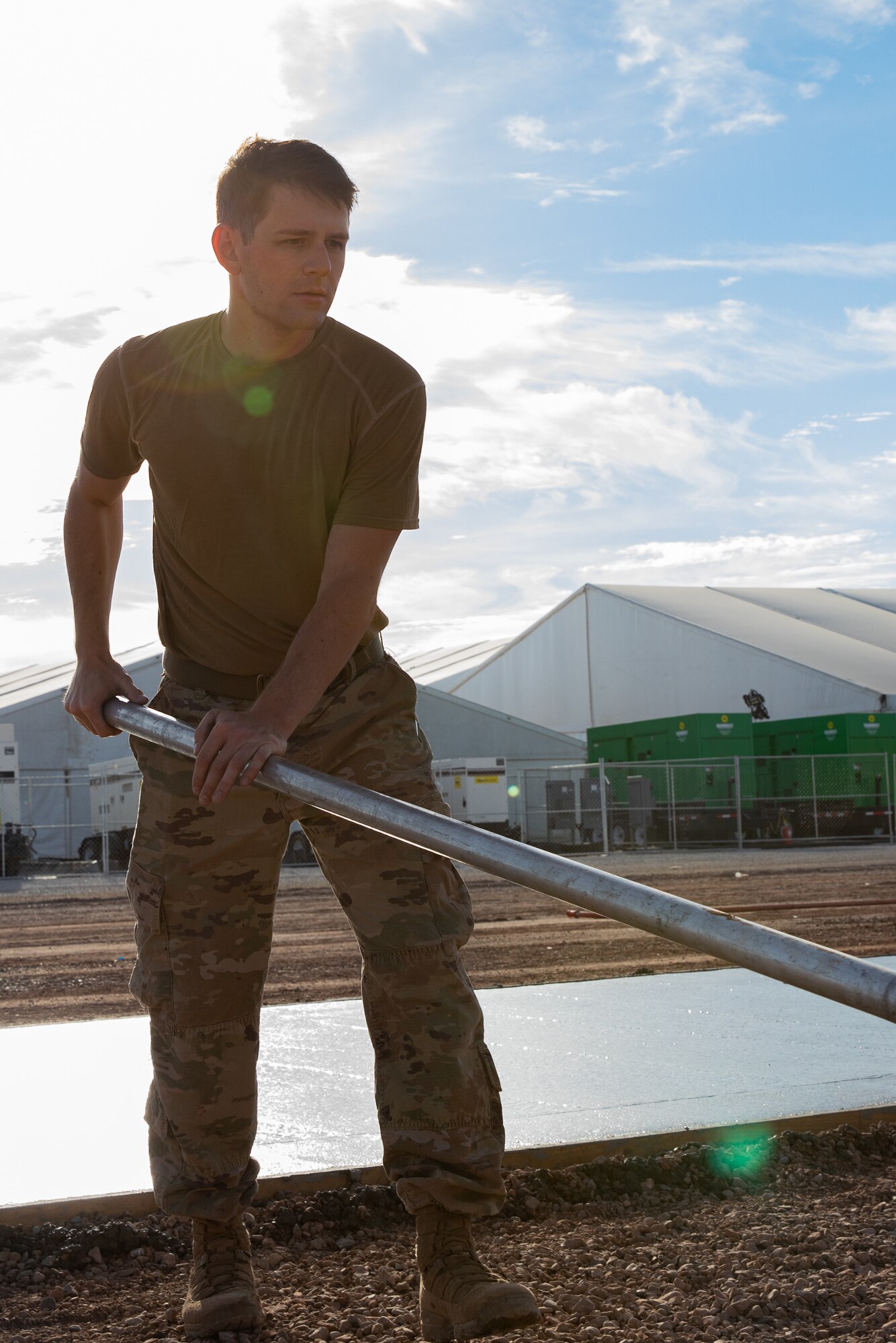 An Airman assigned to Task Force-Holloman smooths fresh concrete for a recreational area for Afghan evacuees on Holloman Air Force Base, New Mexico, Sept. 23, 2021. The Department of Defense, through the U.S. Northern Command, and in support of the Department of State and Department of Homeland Security, is providing transportation, temporary housing, medical screening, and general support for at least 50,000 Afghan evacuees at suitable facilities, in permanent or temporary structures, as quickly as possible. This initiative provides Afghan evacuees essential support at secure locations outside Afghanistan. (U.S. Army photo by Spc. Nicholas Goodman)