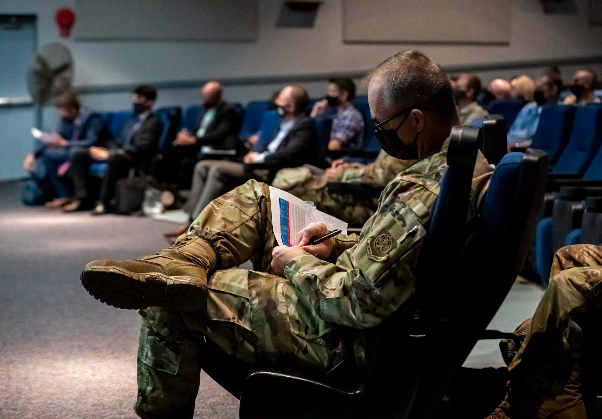 Chief Master Sgt. Timothy Bayes, 436th Airlift Wing command chief, takes notes while listening to guest speaker Chris Locke during a mental health seminar at Dover Air Force Base, Delaware, Sept. 28, 2021. Locke, a 436th Airlift Wing honorary commander, formed the SL24 UnLocke the Light Foundation to educate and assist those dealing with depression and suicidal thoughts after losing his son, Sean, to suicide in 2018. (U.S. Air Force photo by Senior Airman Stephani Barge)