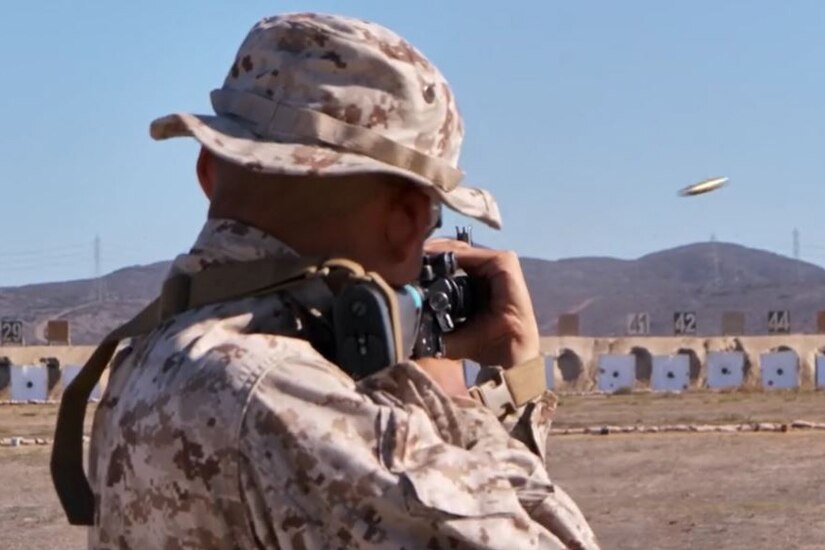 A Marine recruit fires a rifle at a target.