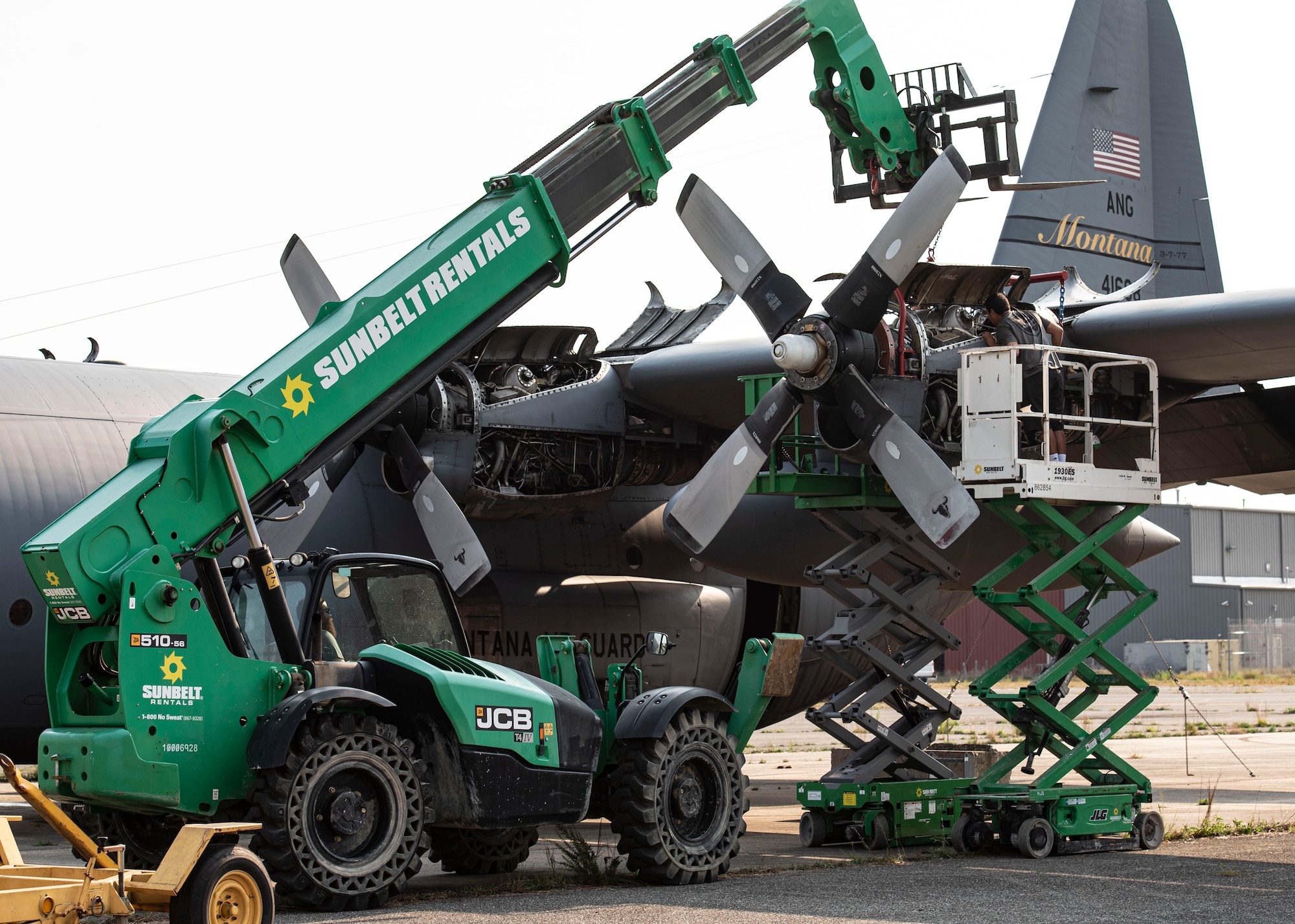 Photo of contractors removing a C-130 Hercules engine.