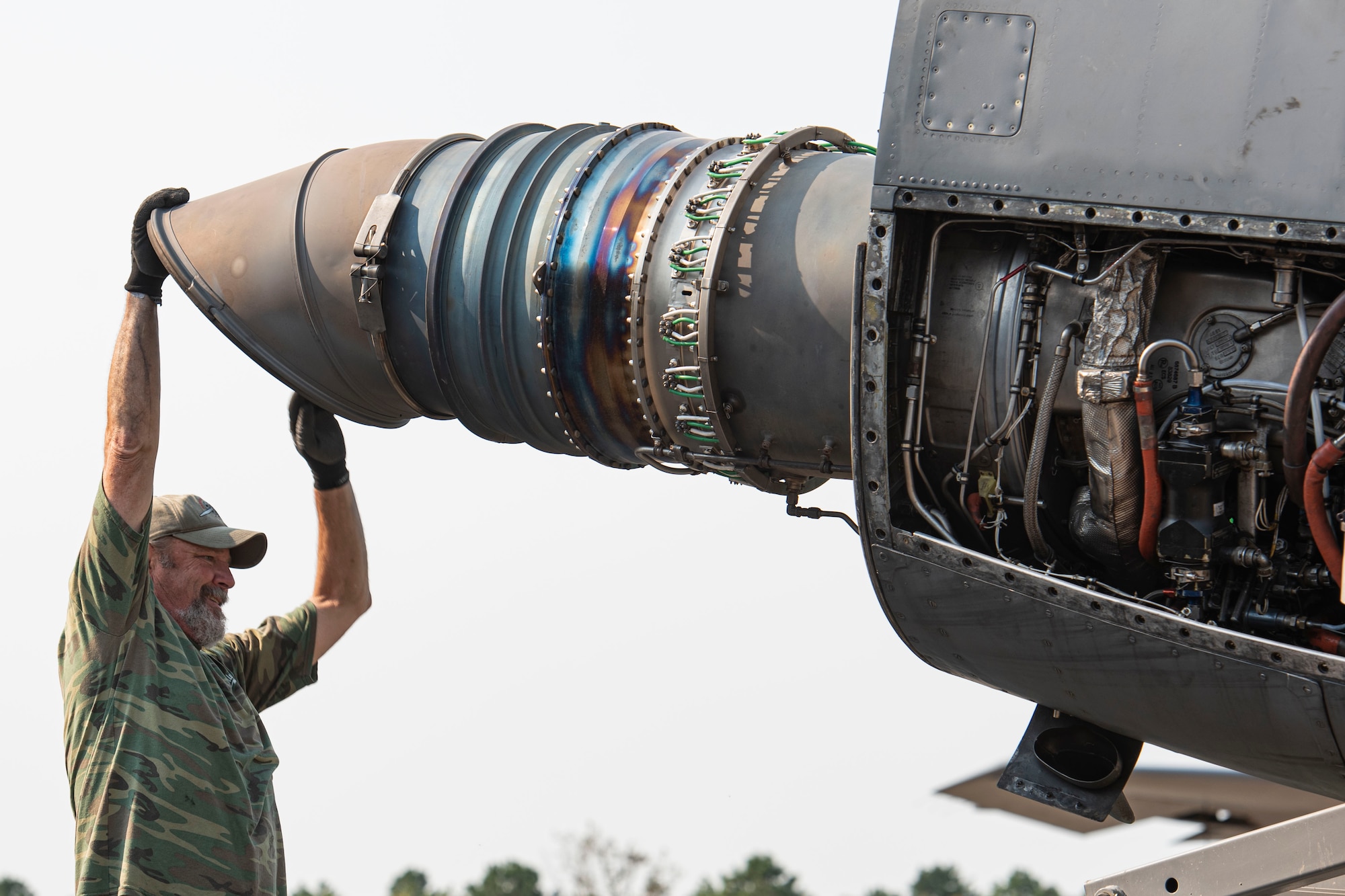 Photo of a contractor repositioning a C-130 Hercules engine.
