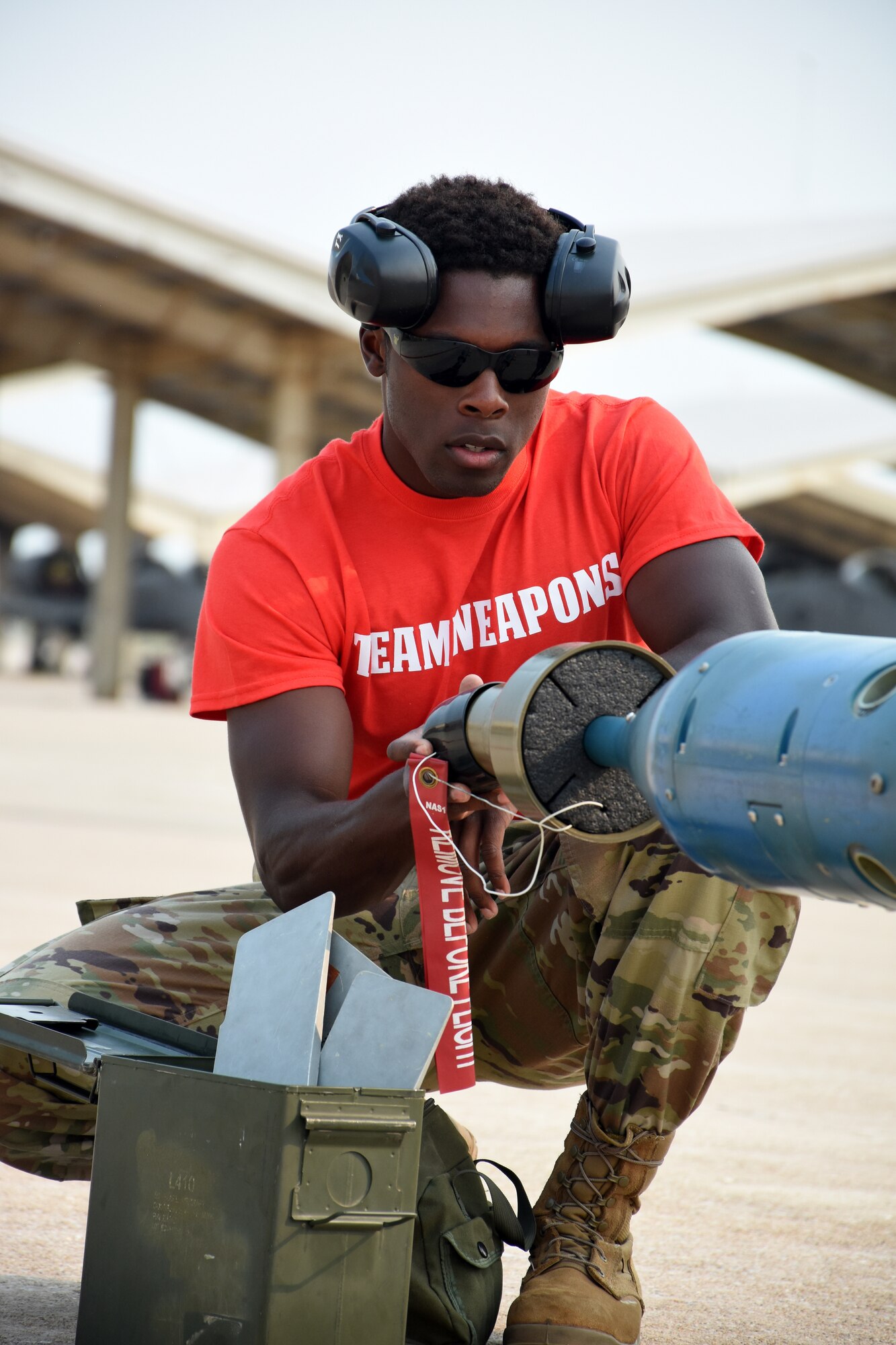 A man inspects a cap on a bomb.