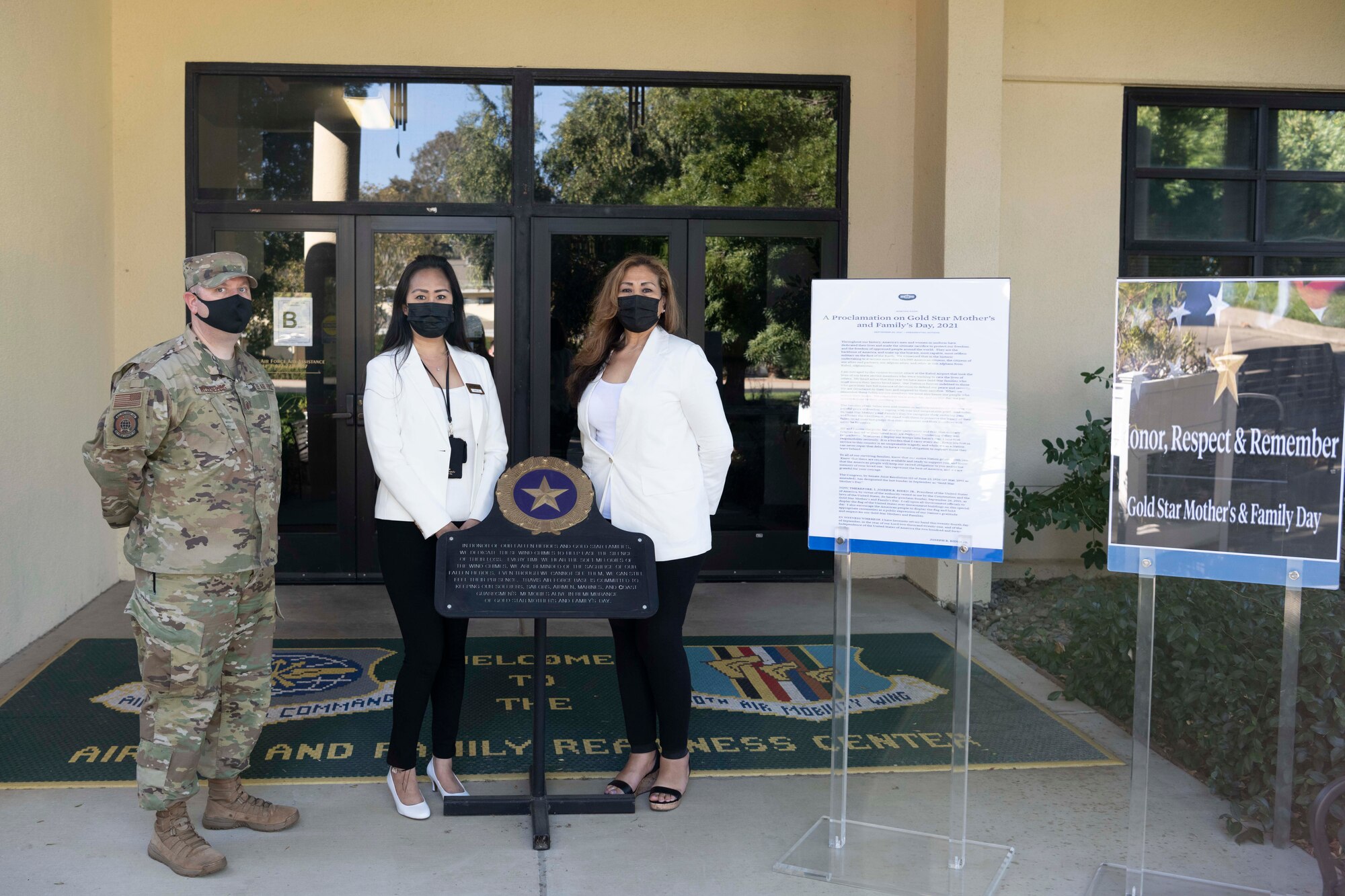people gather around plaque for a photo