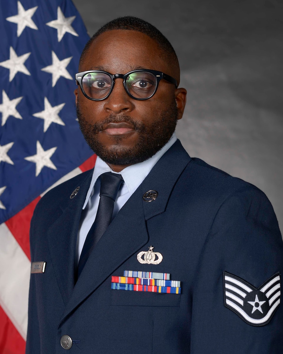 Airman posed in front of a flag