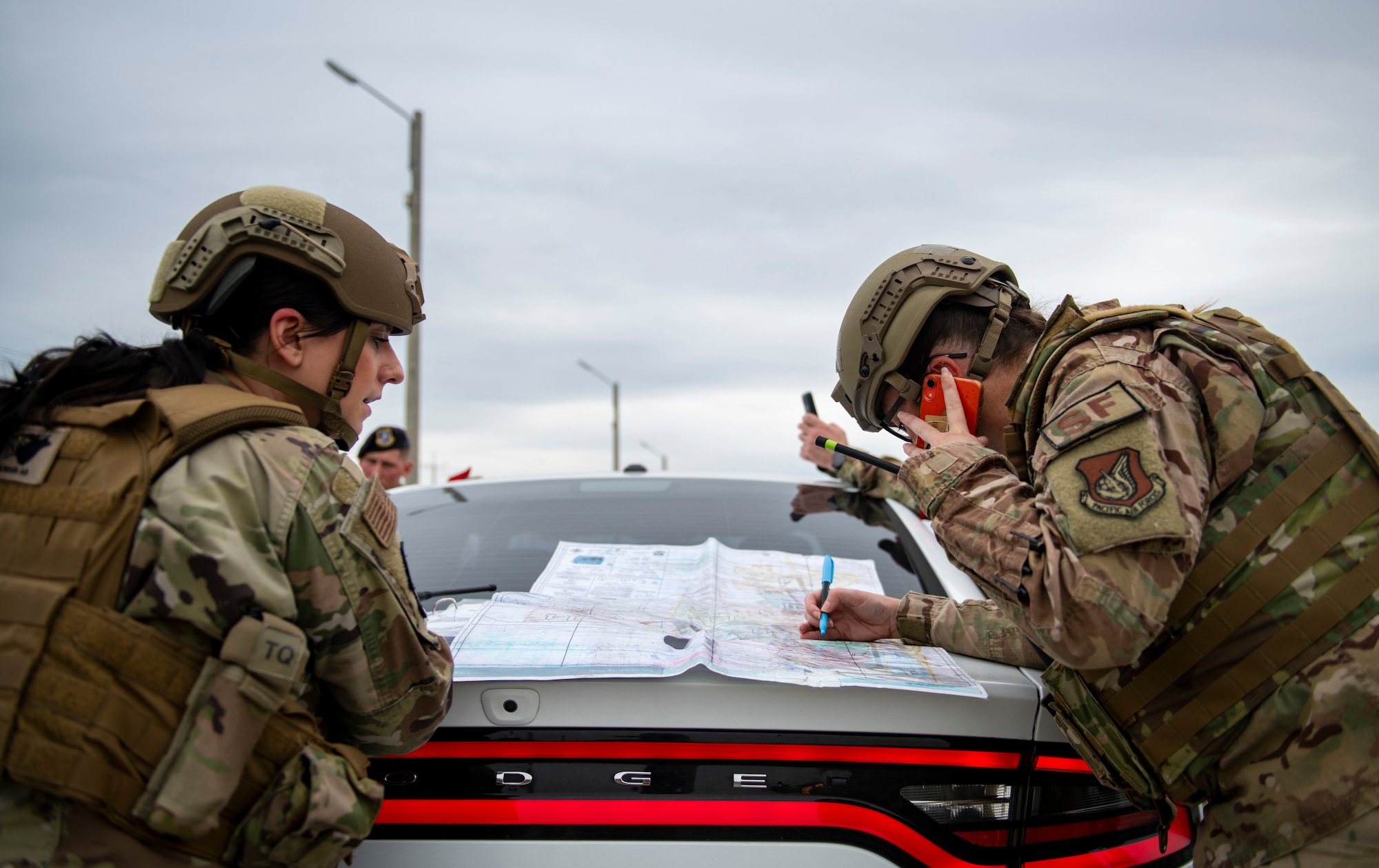 First Lt. Hailey Spears, 8th Security Forces Squadron flight commander, and Tech. Sgt. Megan Gulledge, 8th SFS flight chief, plot cordons during a simulated training exercise at Kunsan Air Base, Republic of Korea, Sept. 28, 2021. In response to a suspected improvised explosive device, the defenders cordon off the scene, allowing a safe distance between the device and any base personnel. (U.S. Air Force photo by Senior Airman Suzie Plotnikov)