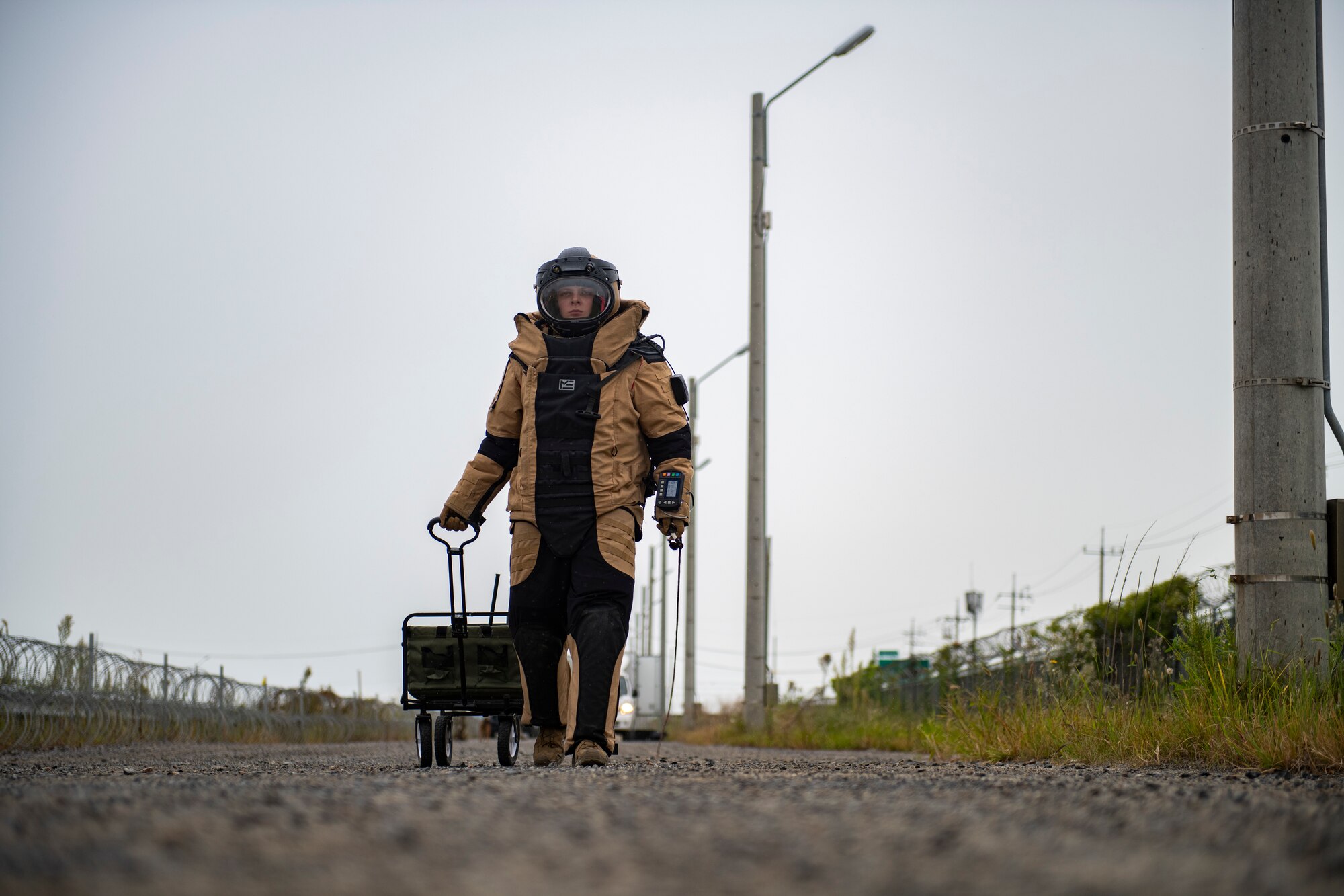 Staff Sgt. Mark White, 8th Civil Engineer Squadron explosive ordnance disposal technician, walks toward a vehicle with a suspected ordnance item during a simulated training exercise at Kunsan Air Base, Republic of Korea, Sept. 28, 2021. The bomb suit is an EOD technician's full-body shield and sole source of protection against an explosive threat. (U.S. Air Force photo by Senior Airman Suzie Plotnikov)