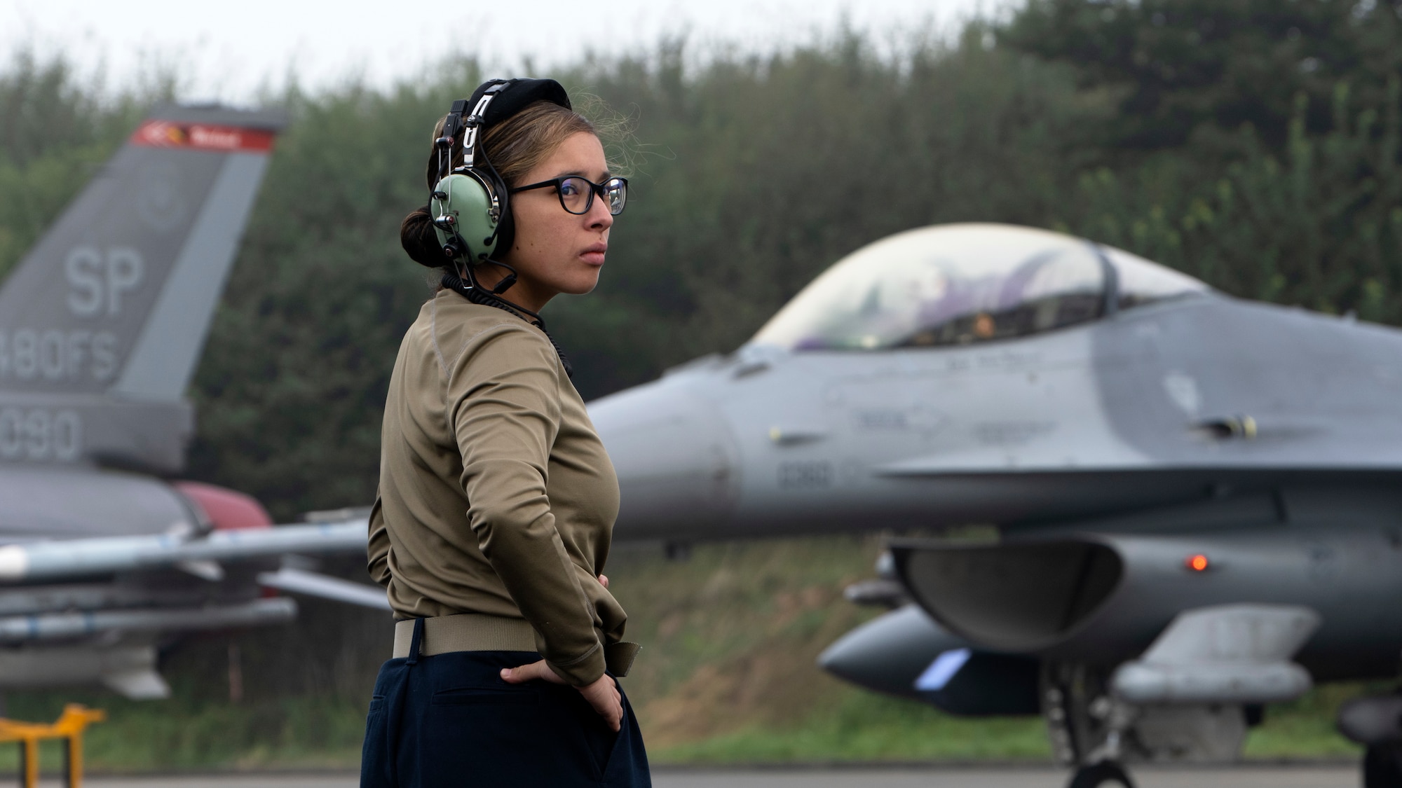 U.S. Air Force Senior Airman Vanessa Reddekopp, 52nd Aircraft Maintenance Squadron weapons load crew member from Spangdahlem Air Base, Germany, prepares to help launch F-16 Fighting Falcon aircraft at Leeuwarden Air Base, Netherlands, Sept. 15, 2021. U.S. Air Force Airmen were in the Netherlands to execute a short-notice Agile Combat Employment deployment. (U.S. Air Force photo by Tech. Sgt. Anthony Plyler)