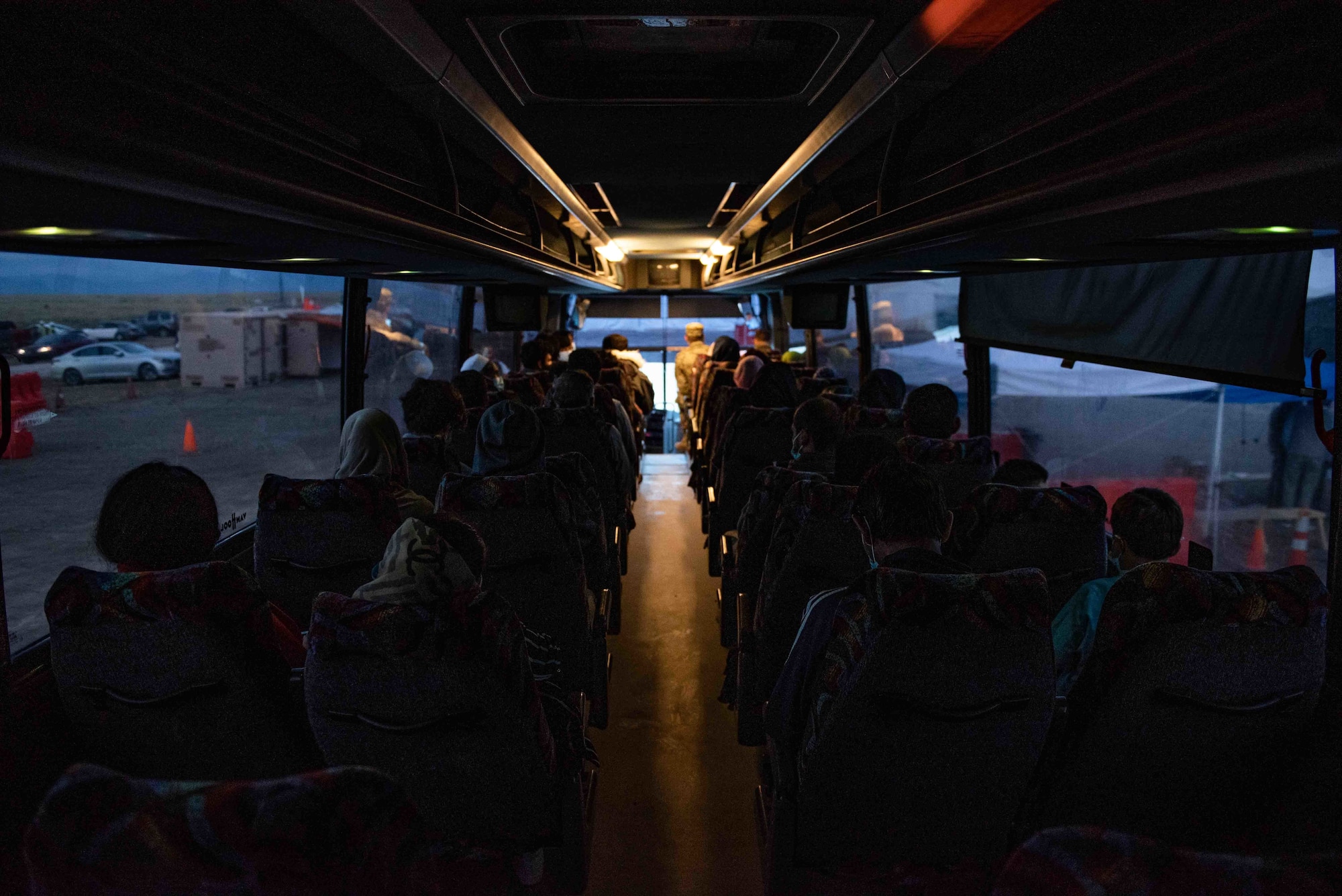 Afghan families wait on a bus at Task Force-Holloman's Aman Omid Village, before starting the resettlement process on Holloman Air Force Base, Sept. 28, 2021. The Department of Defense, through U.S. Northern Command, and in support of the Department of State and Department of Homeland Security, is providing transportation, temporary housing, medical screening, and general support for at least 50,000 Afghan evacuees at suitable facilities, in permanent or temporary structures, as quickly as possible. This initiative provides Afghan evacuees essential support at secure locations outside Afghanistan. (U.S. Air Force photo by Staff Sgt. Kenneth Boyton)