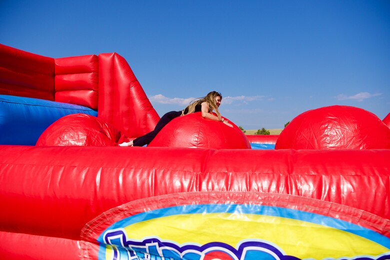 A member of Schriever Space Force Base, Colorado, participates in the Leaps and Bounds inflatable obstacle challenge during an Olympic-themed Wingman Day, Aug. 6, 2021. Wingman Day events also included football, kickball, dodgeball, volleyball, tug-of-war and other activities. (U.S. Space Force photo by Kristian DePue)