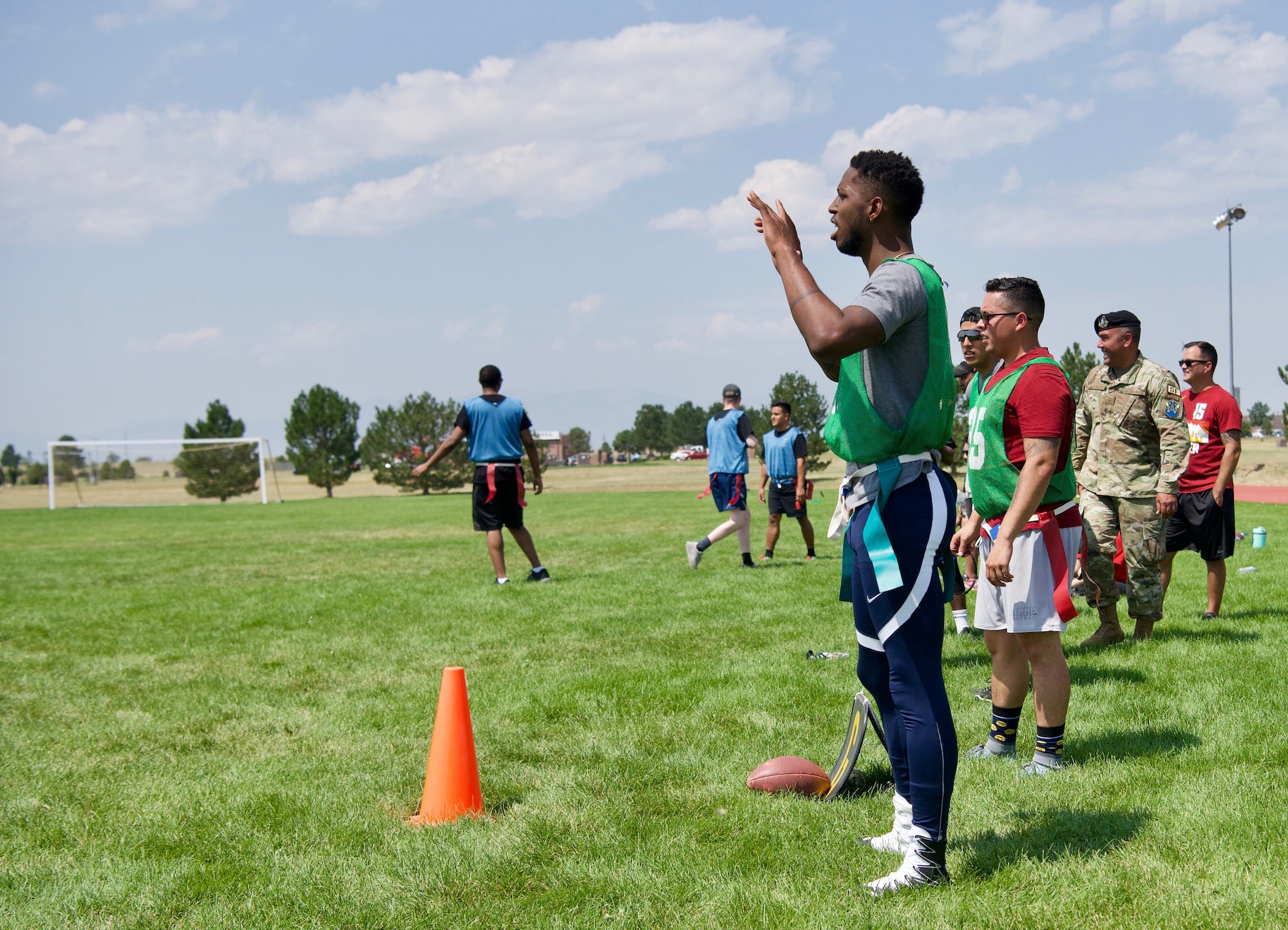 Members of Schriever Space Force Base, Colorado, react on the sidelines of flag football during the biannual Wingman Day, Aug. 6, 2021. After a commander’s kick off, Wingman Day included an obstacle course, flag football, kickball, dodgeball, volleyball, tug-of-war, dancing and leisurely lawn games. (U.S. Space Force Photo by Kristian DePue)