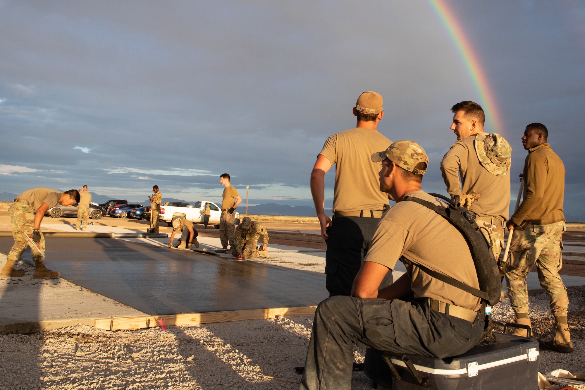 Airmen assigned to Task Force-Holloman smooth fresh concrete in a newly poured recreational area for Afghan evacuees on Holloman Air Force Base, New Mexico, Sept. 24, 2021. The Department of Defense, through the U.S. Northern Command, and in support of the Department of State and Department of Homeland Security, is providing transportation, temporary housing, medical screening, and general support for at least 50,000 Afghan evacuees at suitable facilities, in permanent or temporary structures, as quickly as possible. This initiative provides Afghan evacuees essential support at secure locations outside Afghanistan. (U.S. Army photo by Spc. Nicholas Goodman)