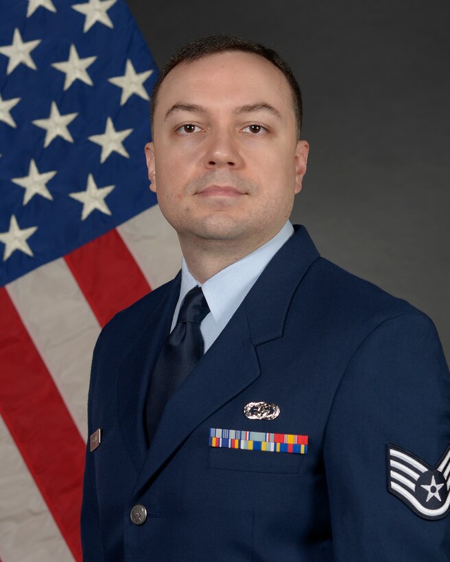 airman posed in front for a flag