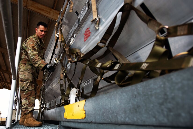 An airman secures a pallet of equipment.
