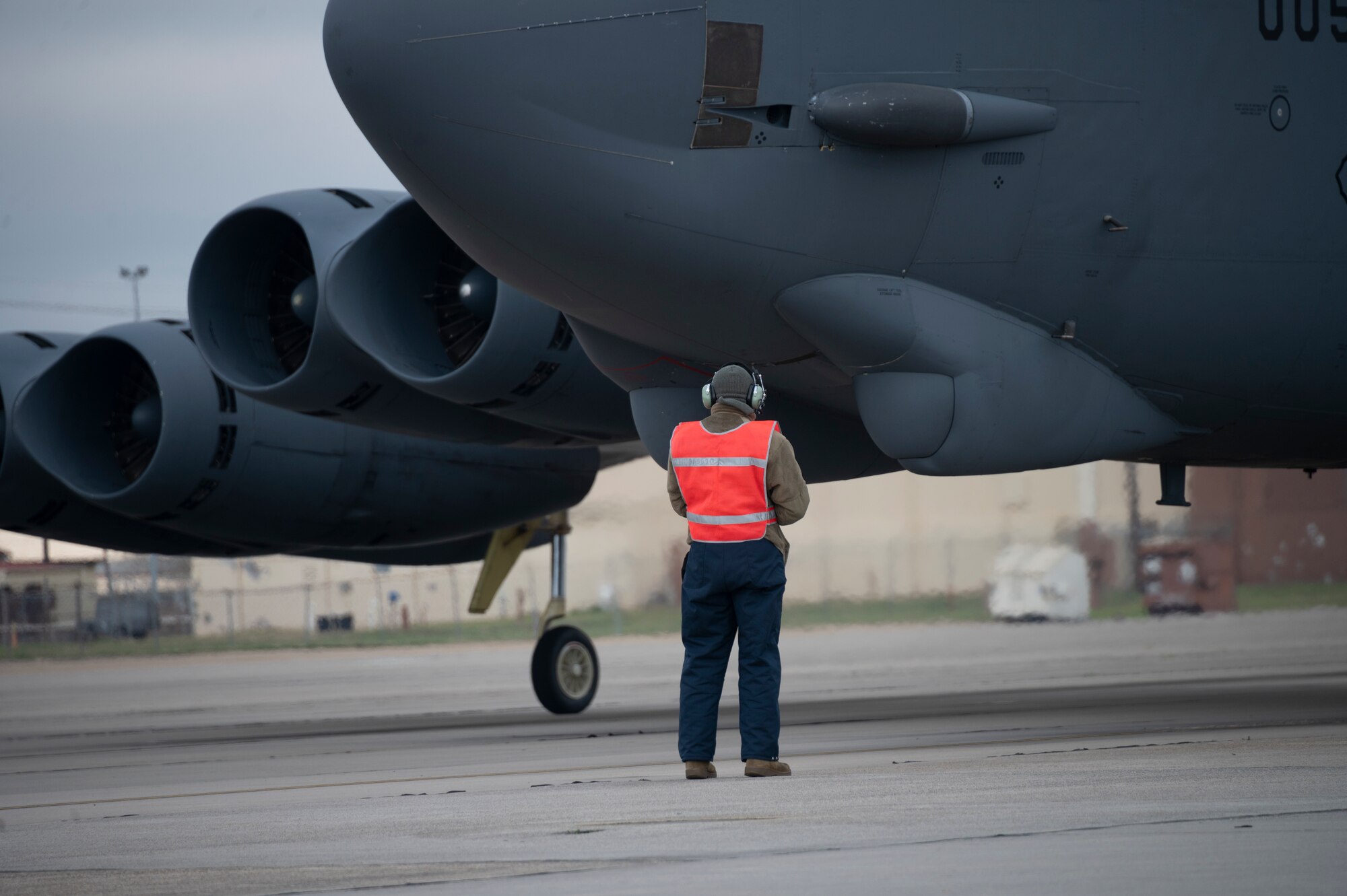 Someone stands near an airplane.