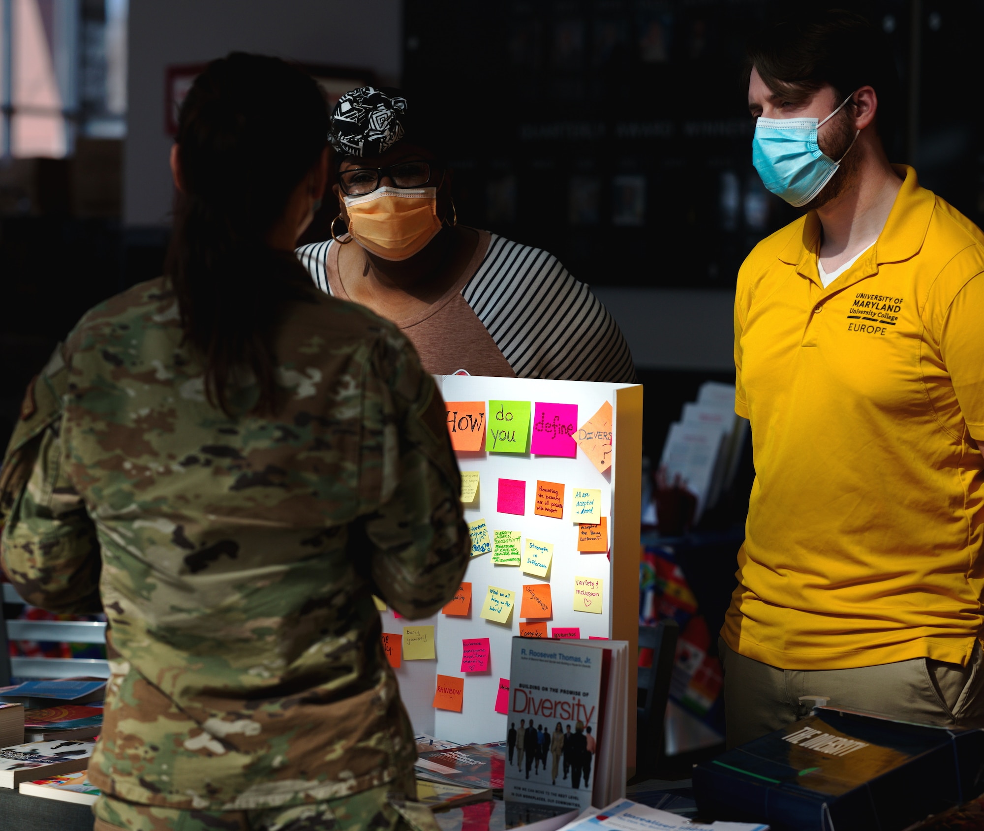 U.S. Air Force Airmen discuss the topic "How do you define diversity?" around a booth at Diversity Day 2022 on Ramstein Air Base, Germany, March 24, 2022. The event encompassed 10 annual observances with educational stands, cuisines and cultural performances. (U.S. Air Force photo by Senior Airman Branden Rae)